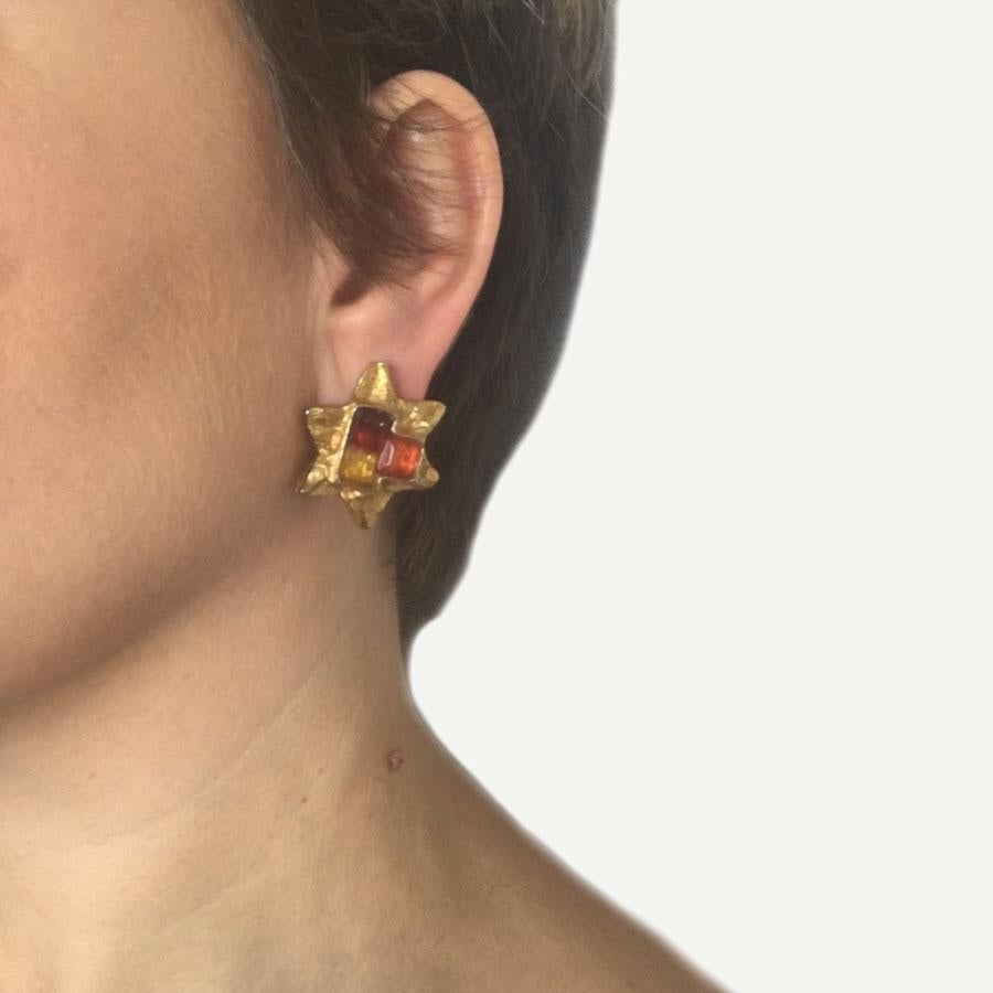 CHRISTIAN LACROIX stars clip-on earrings. Clips in matte gilt metal, in the center 3 faceted plexi stones in yellow, orange and red. 

In very good condition. Pastille of the present brand.

Dimensions: 3x3 cm

Will be delivered in a new,