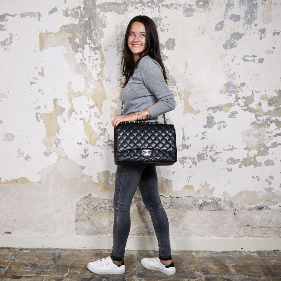 This CHANEL maxi jumbo double flap bag is made of black grained lamb leather. The hardware is in palladium silver metal. 
The interior is in burgundy smooth leather with two flat pockets inside the bag and a large flat pocket at the front of the