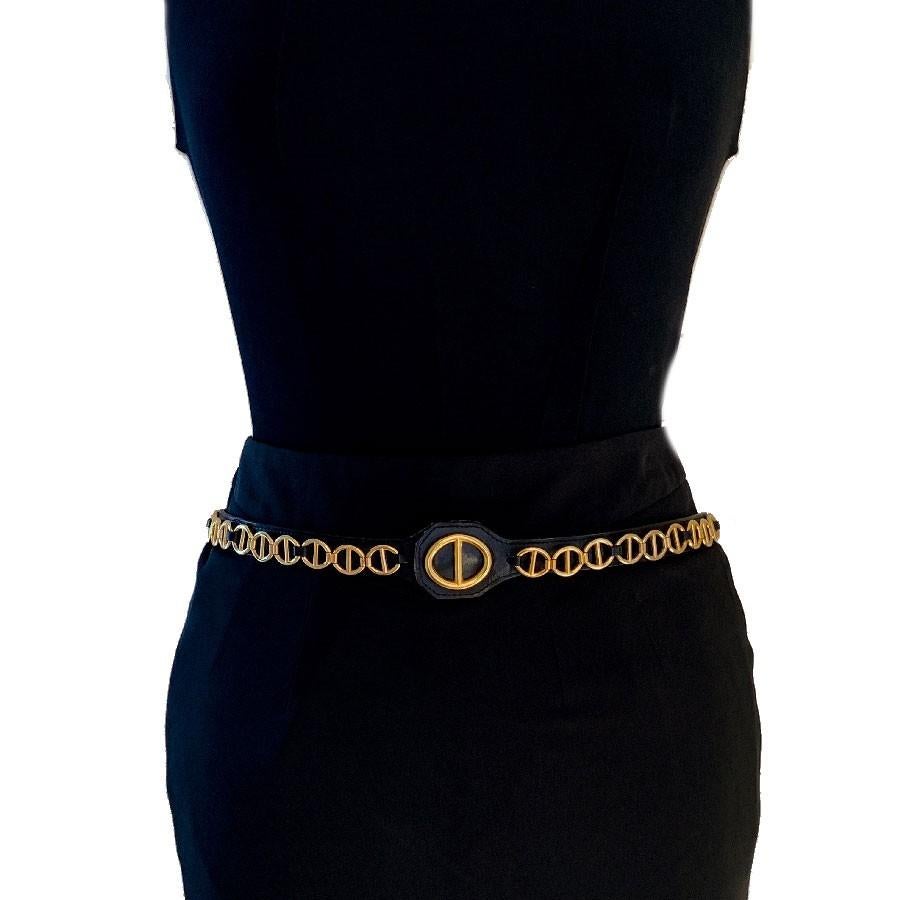 Pretty CHRISTIAN DIOR vintage belt in black calfskin on which there is a chain in gilded metal. The pattern of the chain is found on the all-leather buckle as well. 
This thin belt can be worn with pants, a dress or a jacket to mark your size.
The