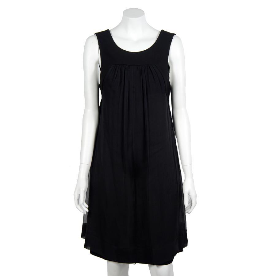 Sublime CHANEL sleeveless cocktail dress with gauzy effect in black chiffon (silk muslin). Size 40FR
It closes at the back with two silver glittered Chanel buttons.

A petticoat in black viscose (rayon) is incorporated in the dress.

In very good
