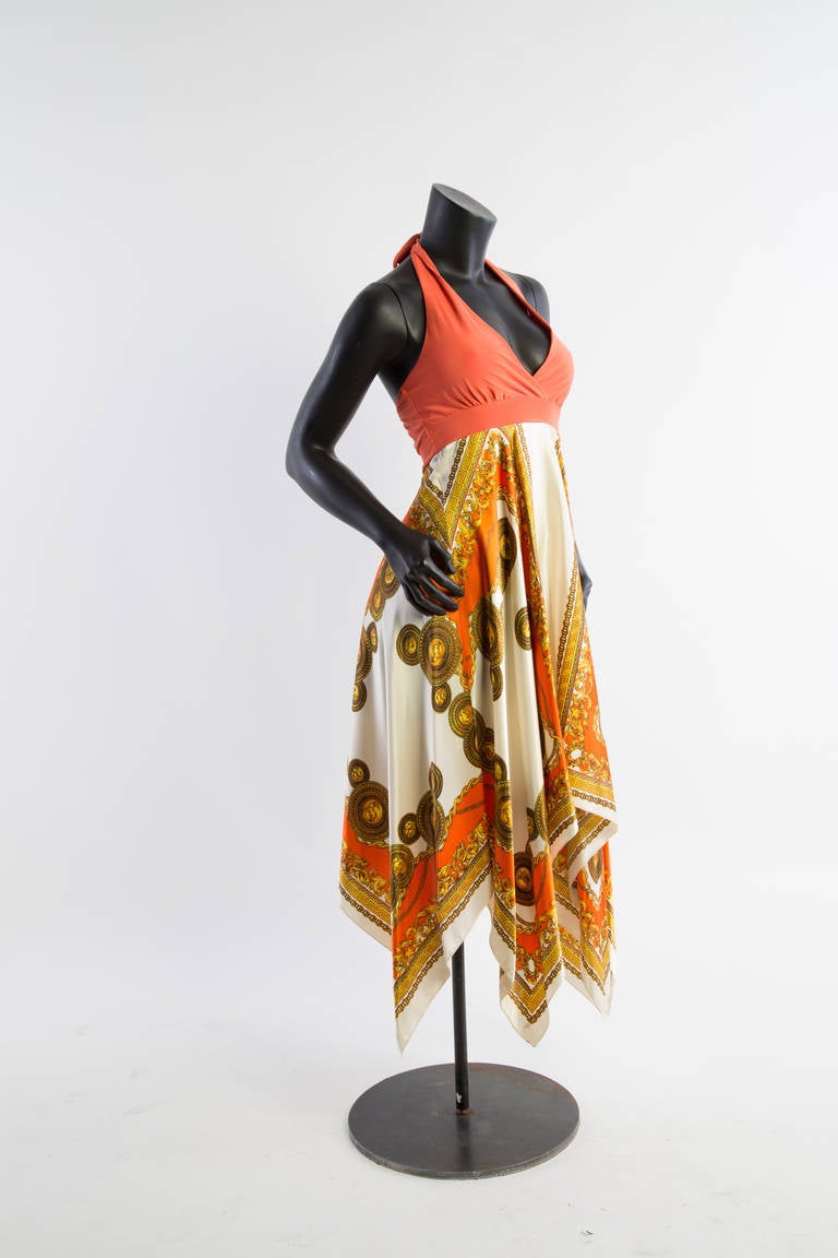 Lanvin empire waisted halter dress c. 1980's. Open back solid orange halter top ties behind the neck allowing adjustment for bust size. Elastic waist allows some variability in sizing as well. Skirt portion in a beautiful graphic orange, gold, and