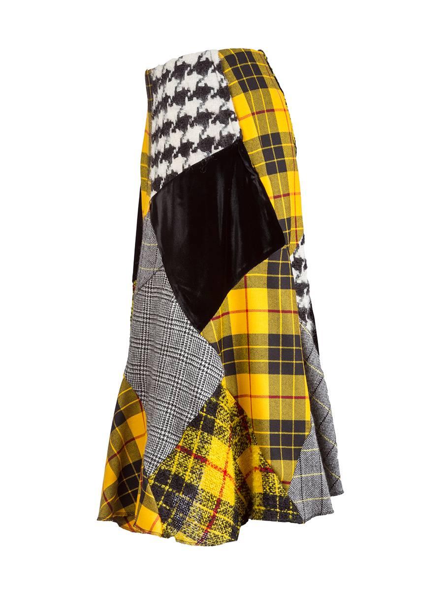 Rare vintage Comme des Garçons wool blend skirt with patch work in plaids, tweeds, mohair and black velvet. This asymmetrical midi skirt flares slightly creating a very flattering silhouette. Back zipper. Early 90's.