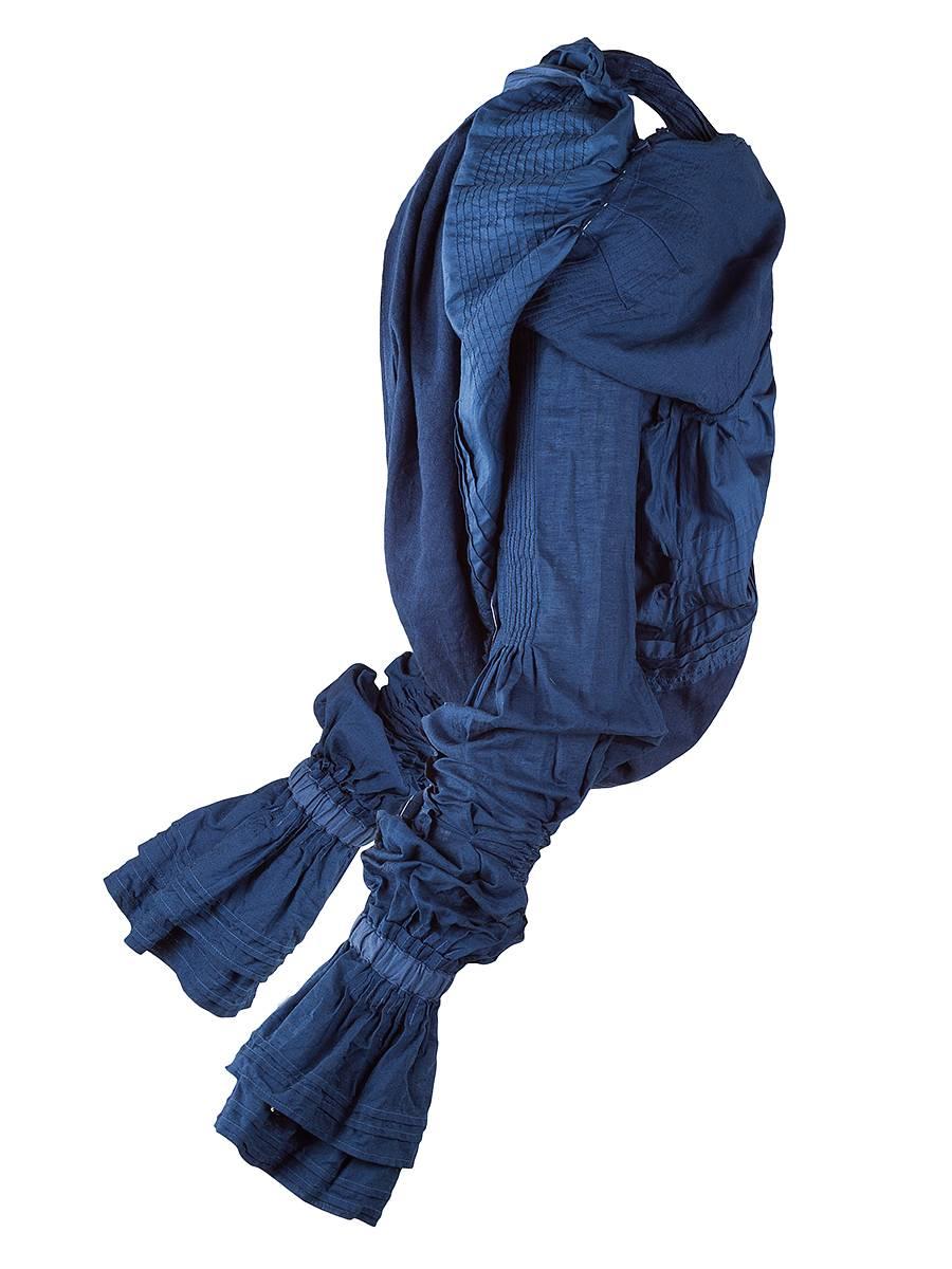 Knotted wrap shrug in blue from Tao Comme des Garcons. This rare vintage cropped wrap style jacket features a folded collar, pleated stitching throughout, and long pleated and ruffled sleeves with slit cuffs. Has button down under arms, a front tie