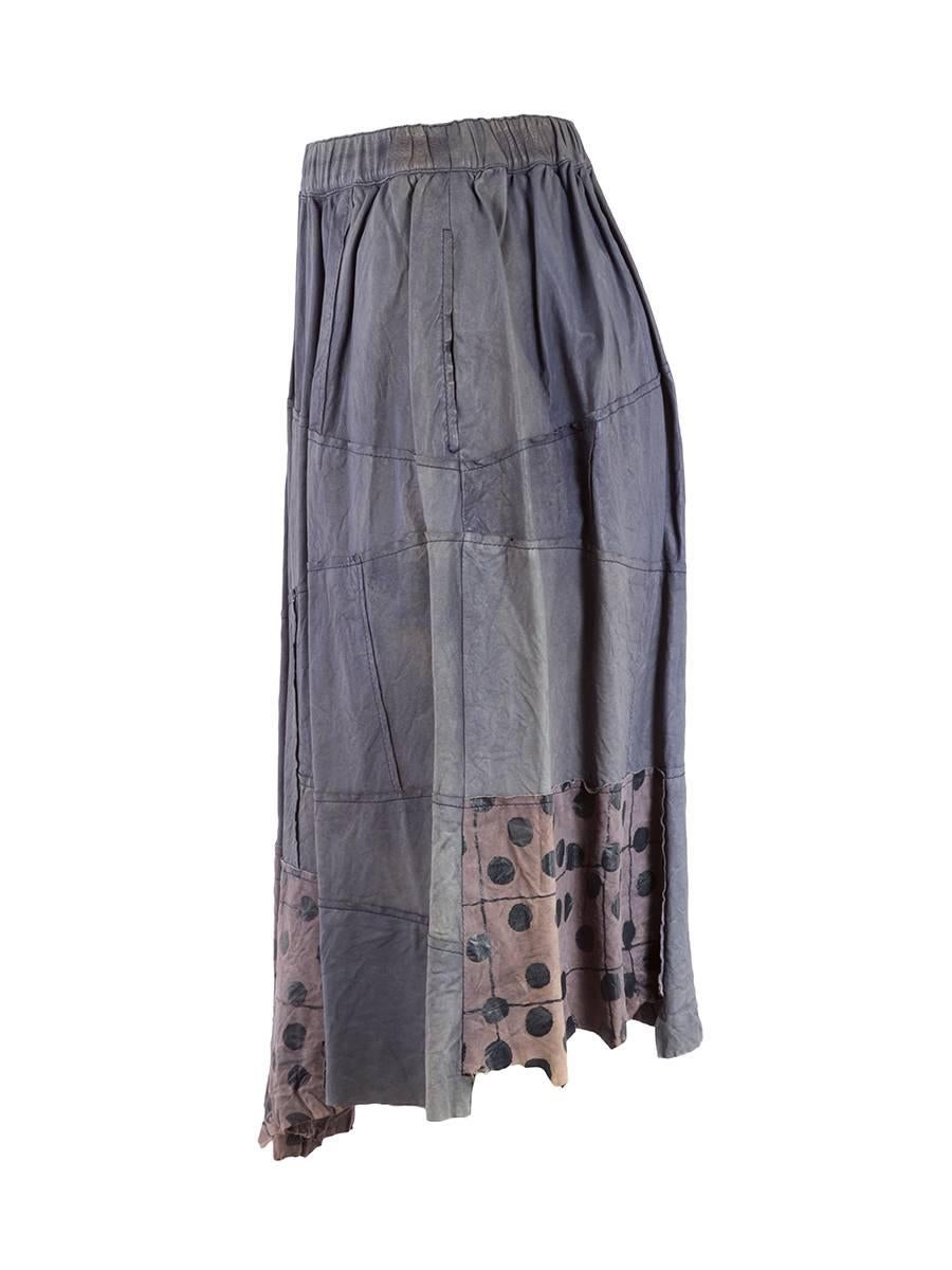 Comme des Garçons Washed leather skirt in shades of dusty blue. This 20th century paneled mid length skirt features a dotted hem, two side seam pockets, and an elastic waistband. 