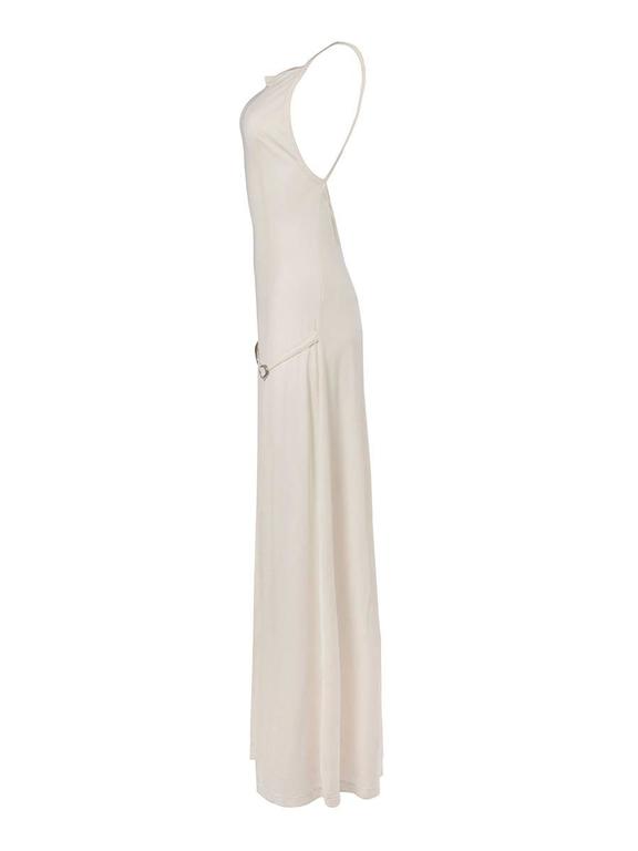 1980's Paco Rabanne stretch knit maxi dress in cream with a criss-cross straps and an open back and a relaxed metal buckle detail waist belt. New with Tag.