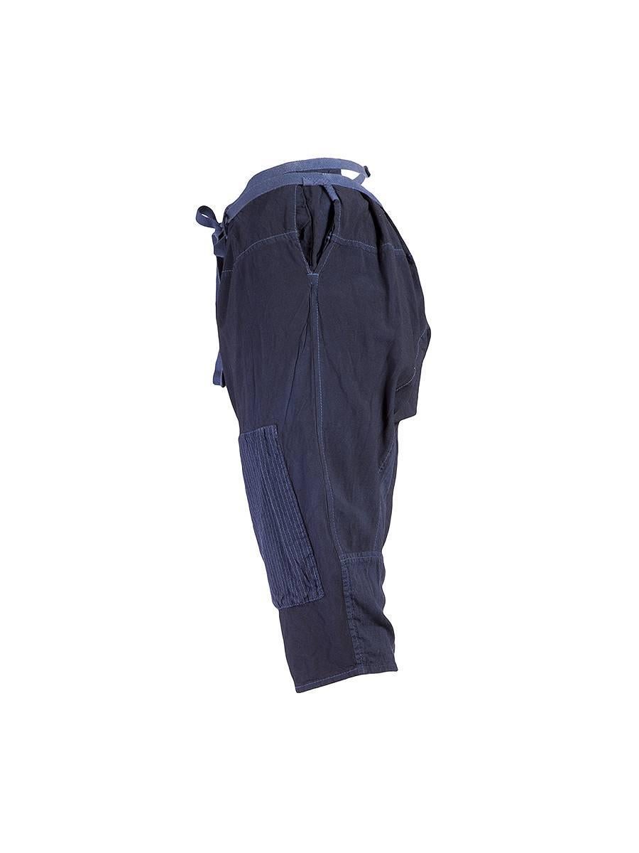 TAO for Comme des Garçons Hand-dyed indigo cotton drop-crotch cropped pants with a drawstring at the low-waist, textured patches at the knees and a waist strap that buttons at back. From the Spring/Summer 2008 Collection. NWT.