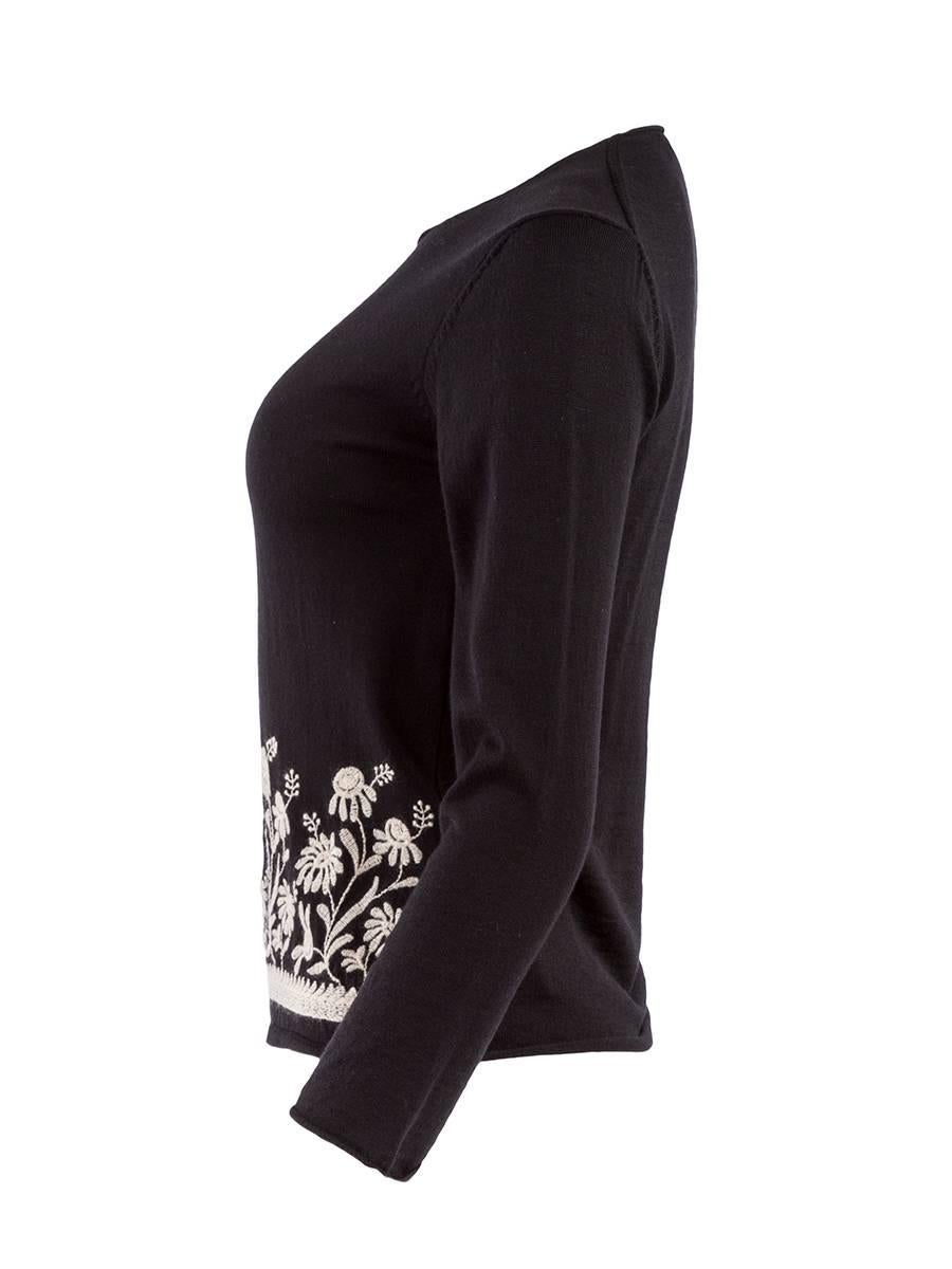 Long sleeved black stretch knit top from Comme des Garçons circa 1990's featuring a rounded neckline and white floral embroidery around the bottom. New with Tag.