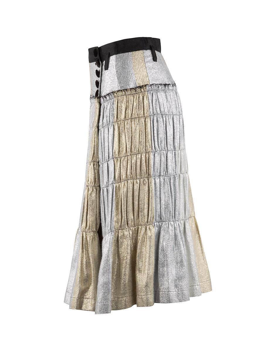 Rare 21st Century Tao Comme des Garçons gold and silver tiered pleated skirt featuring sparkly gold and silver horizontal stripes, a black waistband, belt loops, and a wrap style front with four velvet button closure.