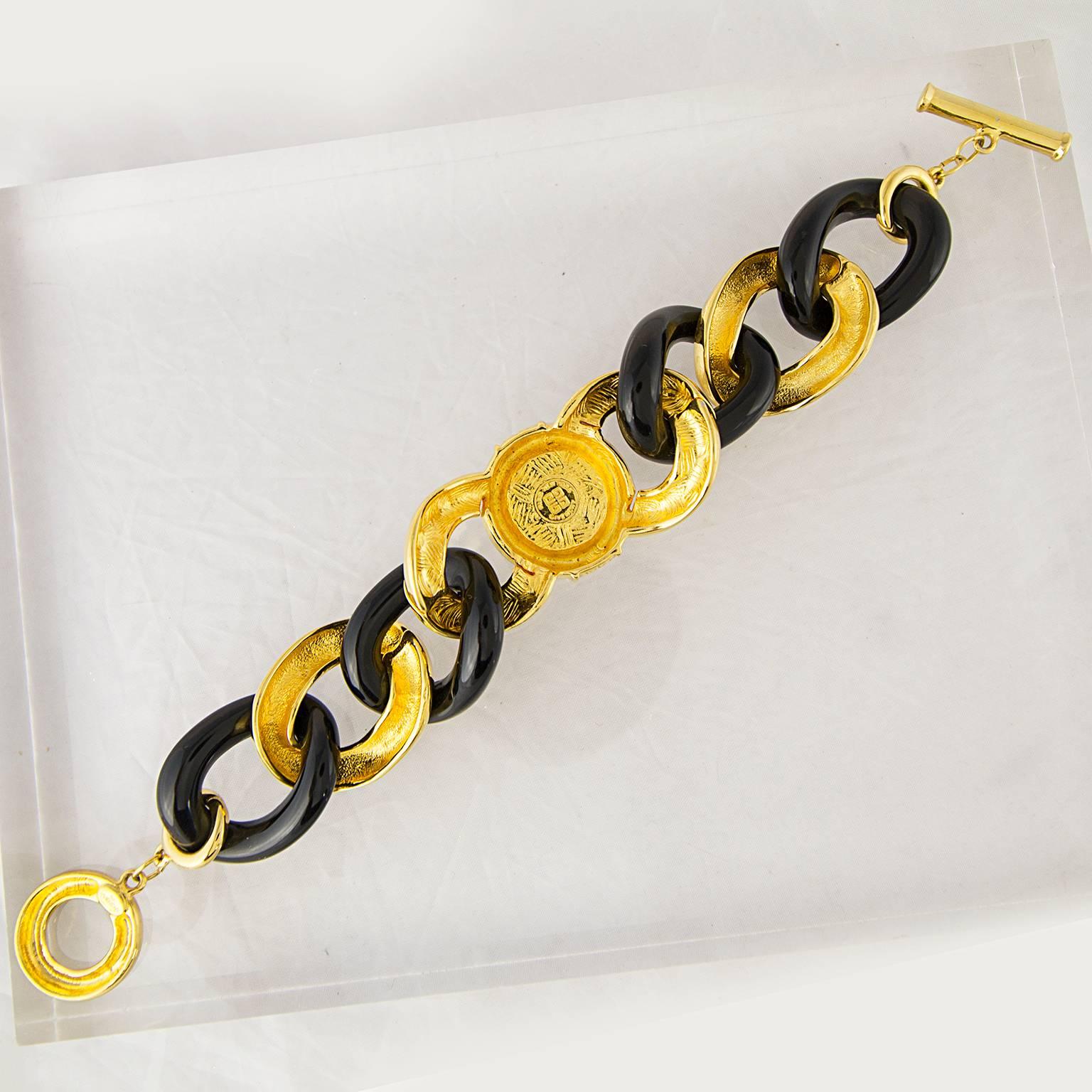 A fashionable Givenchy chain bracelet in gold plated metal and black resin with faux pearl and logo detail.
Fully signed. 
In a fantastic like new condition. 
Don't hesitate to contact us with any queries or image requests.
