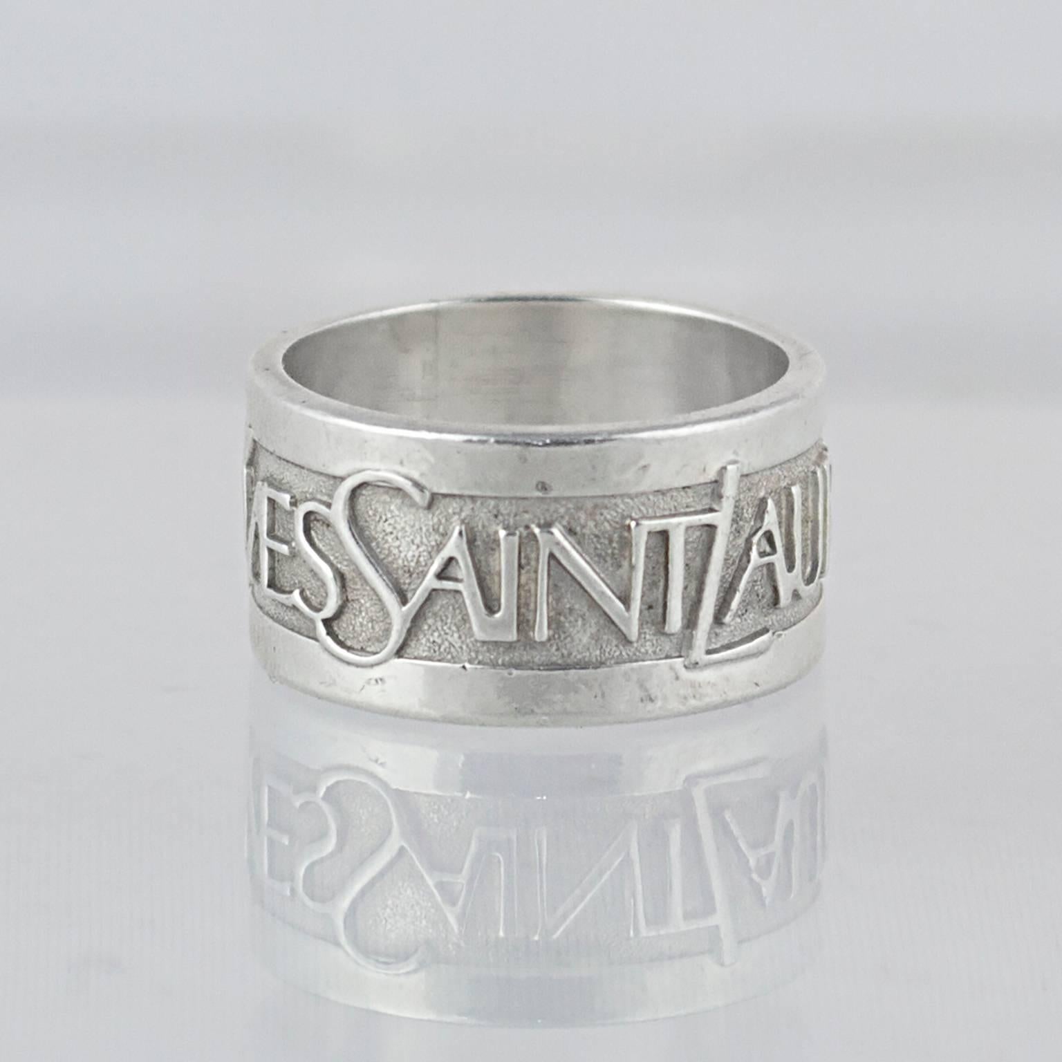 A statement YSL sterling silver ring with engraved 'Yves Saint Laurent' motif. 

1990's. 

Sterling silver, marked 925 with French hallmarks. 

Fully signed. 

In a great pre-loved condition. 

Don't hesitate to contact us with any queries or image