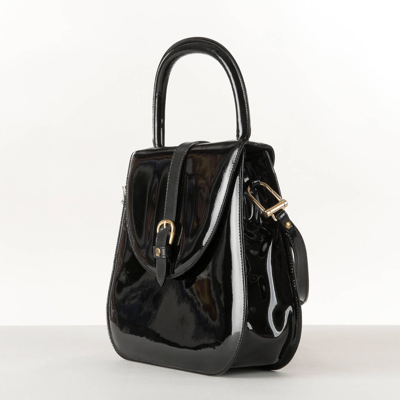 This very smart black patent leather bag by Etienne Aigner is a real 'special event' bag. With great attention to detail, the centre strap is in contrasting matt leather with a magnetic, gold buckle clasp. the interior is in beige knap-leather with