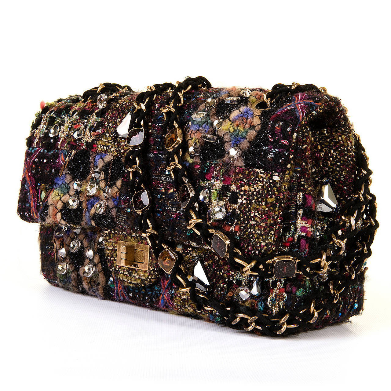 This fabulous, rare bag by Chanel is a real 'Tour de Force'. The multicoloured Tweed is decorated all over with different coloured  cut-glass stones, gold link chain, silver stars and other bijou adornment. The  double interwoven handles are also