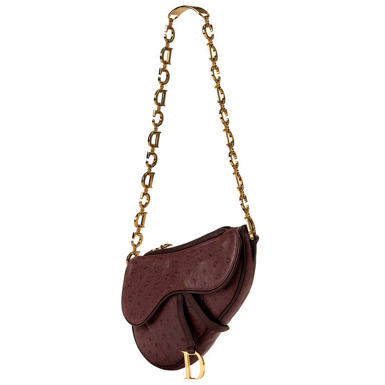 An Absolutely stunning, top of the range, Handbag by Christian Dior. Finished in exotic Ostrich-skin with a beautifully crafted Gold-tone 'C.D.' logo handle, the combination of the Aubergine coloured Ostrich-skin with the bold gold-tone logo-handle,