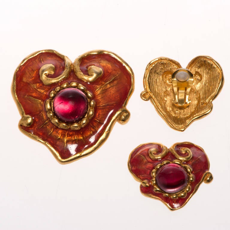 A stand-out set of Heart Shaped Clip-on Earrings with a matching Pendant/ Brooch by the famous, chic, Paris Designer, Christian Lacroix. Each piece is finished with gilt & enamel decoration, centered with a richly coloured glass stone.