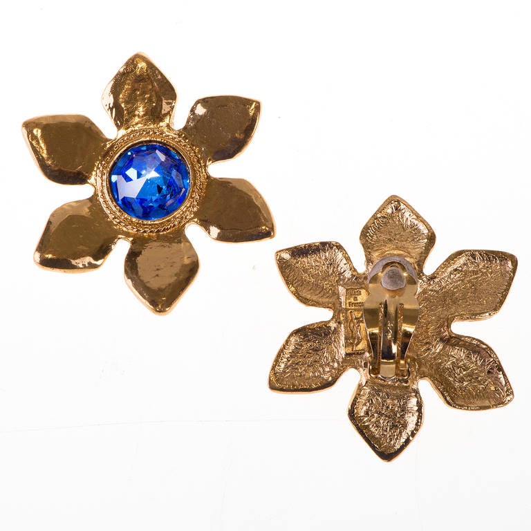 You are sure to get noticed in these stunning clip-on earrings by Yves Saint Laurent. Beautifully made, the hammered gold-tone petals are centered with a gorgeous deep-blue cut glass stone. Signed, 'YSL - made in France'