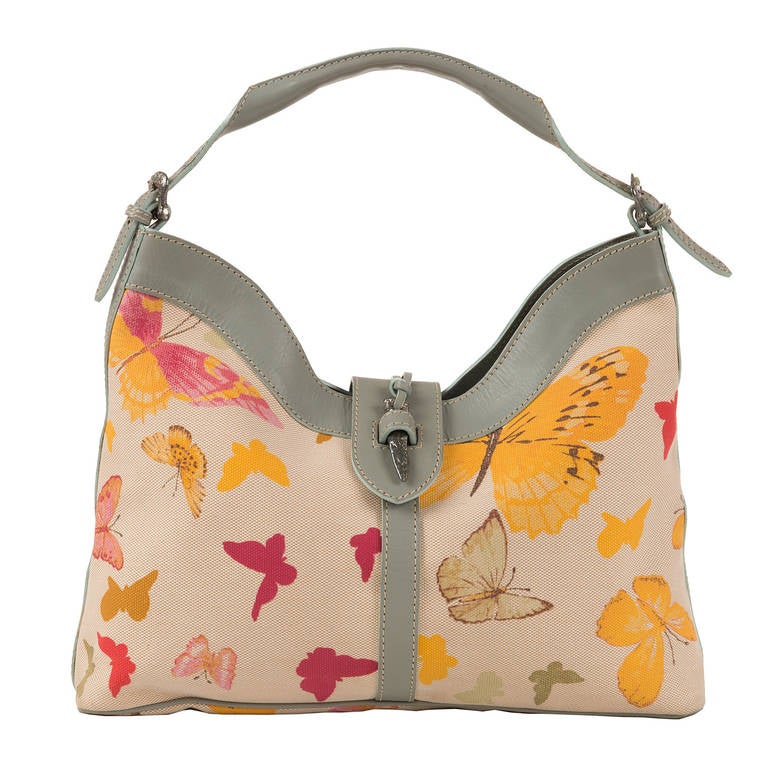 Great Valentino design makes this 'Butterfly' bag the must-have accessory, for the Spring/Summer Seasons. The grey leather trim, with its white saddle stitched seams, is beautifully complemented with the etched silver hardware. Inside the zipped
