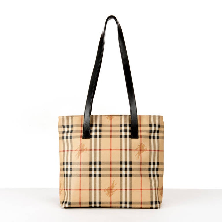 For lovers of Burberry, The iconic 'Burberry-check' !! This is your classic medium Burberry check Tote with dark brown leather handles, that just never goes out of fashion. A statement Bag that shouts classic English style & elegance. The interior