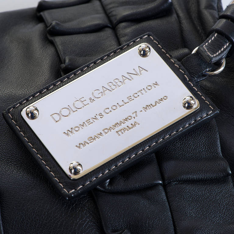 You will love this bag !! In Black Calfskin, the bag is designed with an outside silver palladium 'Label Tag' - engraved Dolce & Gabbana- 'Womens Collection' - Milano, Italia. The interior is finished in a D & B logo, leopard-print, with the