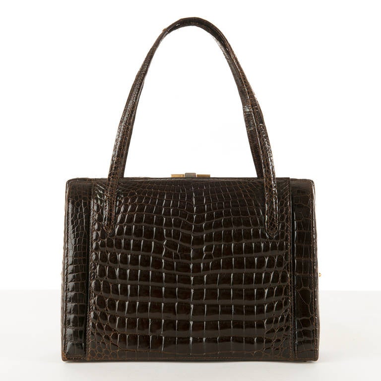 This absolutely beautiful Chocolate brown Porosus crocodile handbag was probably commissioned by Asprey of London, in circa 1960. The exterior has large side pockets to either side and is surmounted with a two tone silver & gold metal clasp, and