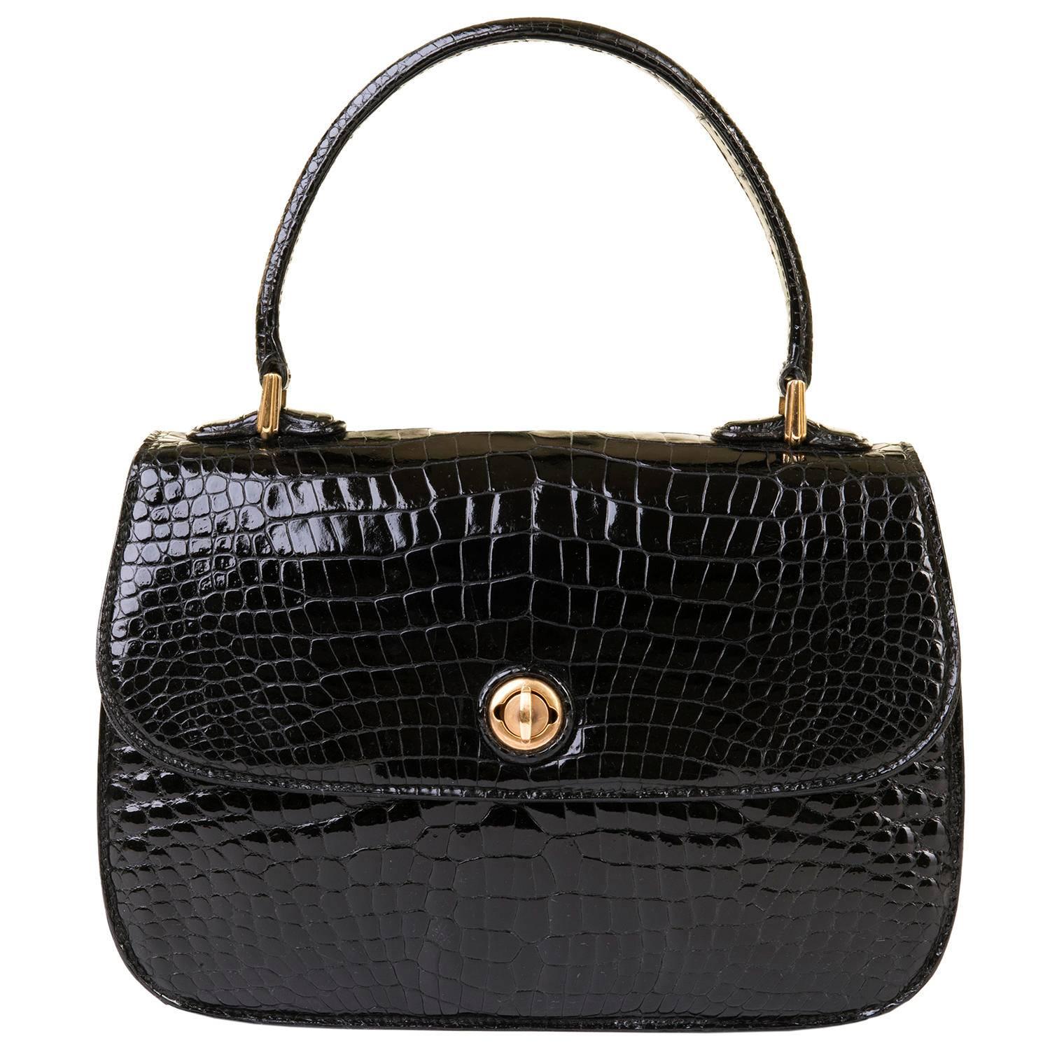A Fabulous and very rare vintage Gucci Black Crocodile handbag with Gold-tone Hardware. Hardly used, the bag is in superb condition and still comes with it's original box & dust sack. Inside is finished in black lambskin with an intergrated fitted