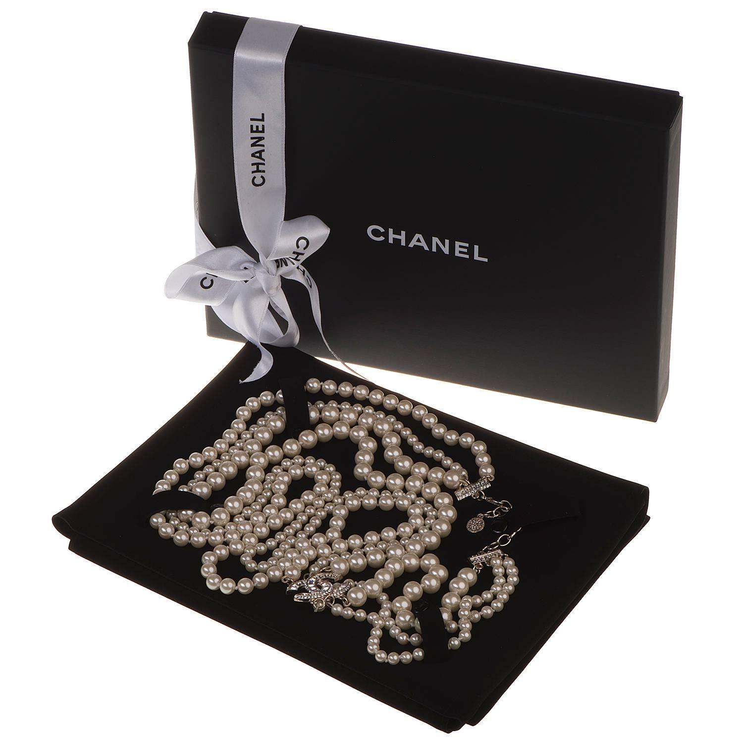 A Fabulous Large Pearl 3-String Sautior by Chanel. In superb, pristine, store-fresh condition the pearls are decorated with the iconic interlocking CC, inset with Art Deco style cut glass stones. This signed piece comes with it's original gift Box &