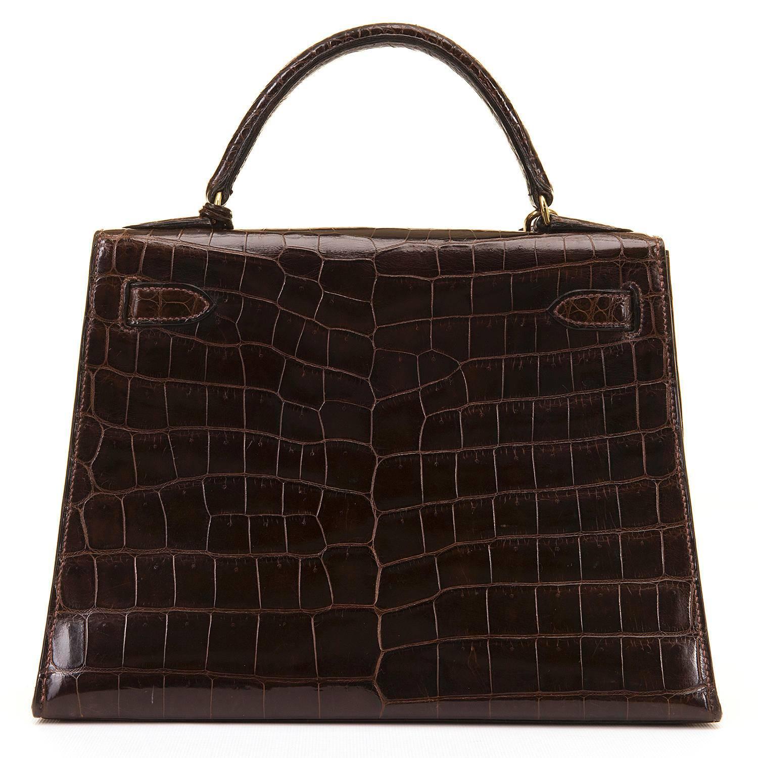 A Pristine Hermes 'Chocolat' Crocodile Kelly Handbag with Goldtone Hardware. This very rare vintage bag comes complete with its padlock, keys & Keyfob, with the interior being finished in matching Chèvre leather. Sourced from a private collection