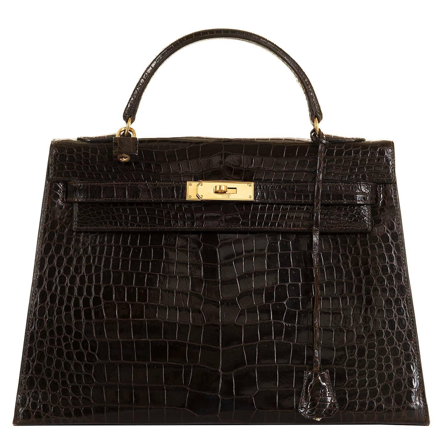 In Pristine condition, this Very Rare Vintage Hermes 'Chocolate' Crocodile Kelly Handbag comes with Goldtone Hardware and a colour-matched interior finished in 'Chèvre' leather. The bag is complete with it's original Crocodile leather covered