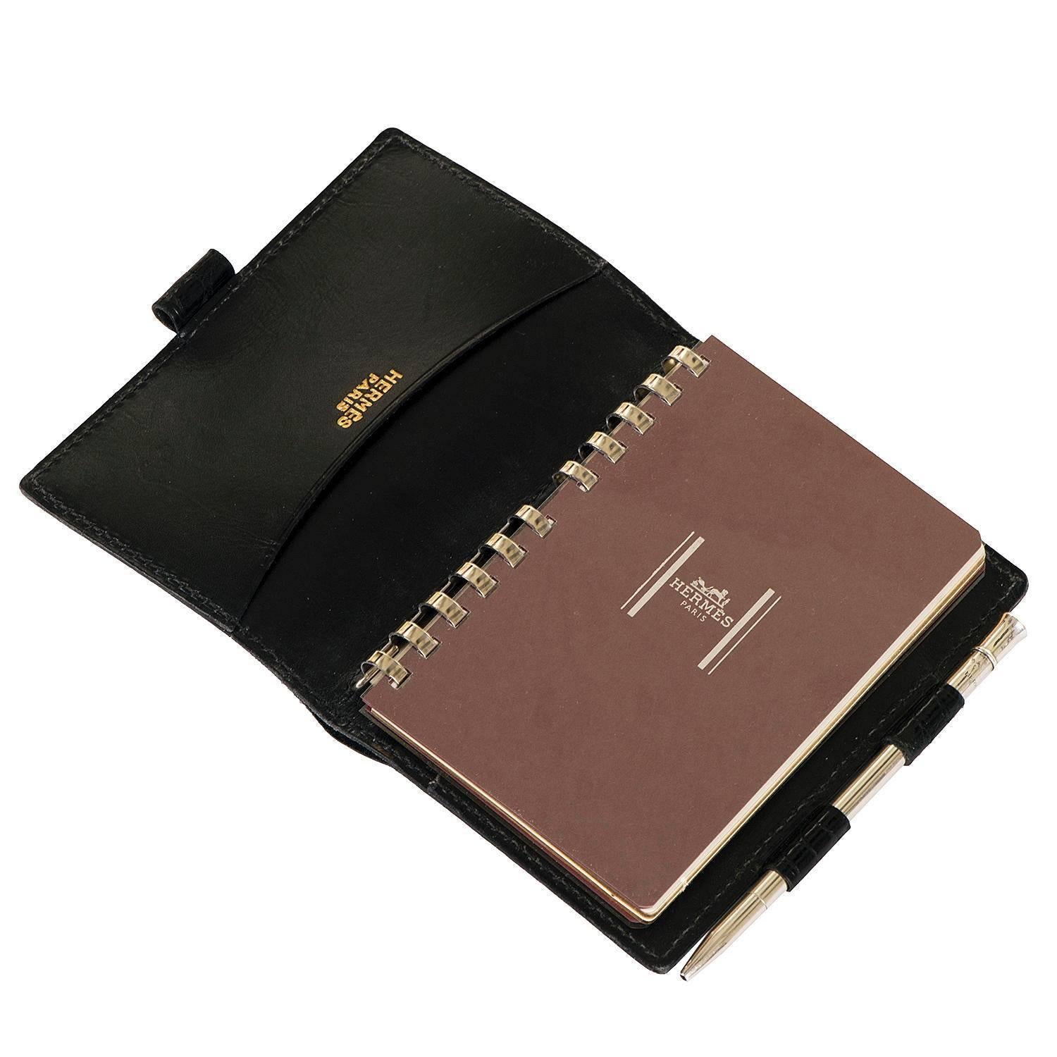 A Rare Vintage Hermes Agenda/Notebook in absolutely pristine condition. Finished in Black Porous Crocodile, the Agenda retains it's original Silver propelling pencil with both the Agenda and silver pencil bearing the Hermes stamp. Fitted with a new
