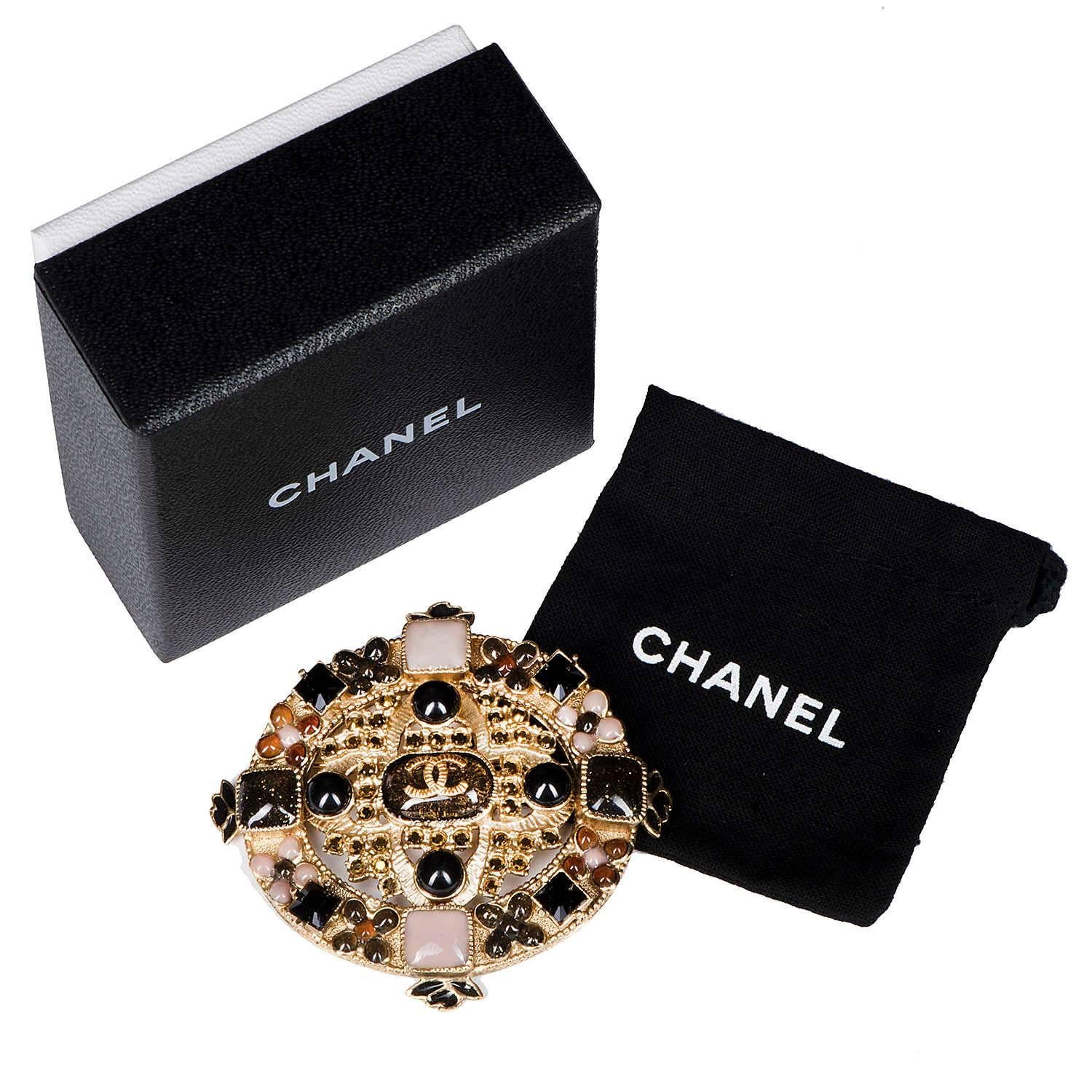 In excellent condition, this Chanel cartouche shaped brooch is a rare find. Centered with an oblong stone surmounted with a raised gold 'CC' Logo, surrounded by 36 yellow coloured cut glass, grain-stones. The top and bottom elements of the brooch