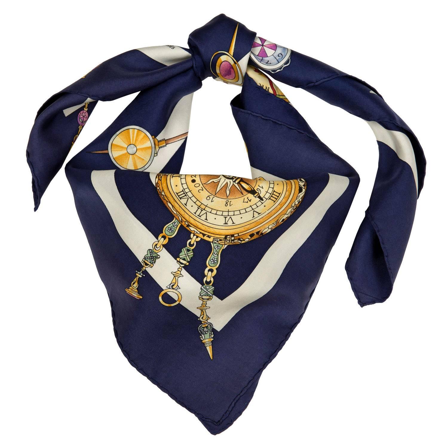 'La Ronde des Heures' - a classic Hermes Silk Scarf designed by Loic Dubigeon in 2000. This Rare Hermes 'Millennium'  celebration scarf finished in sumptuous colours with a Navy Blue Border and Gold & Grey Ground. A real Heritage piece!