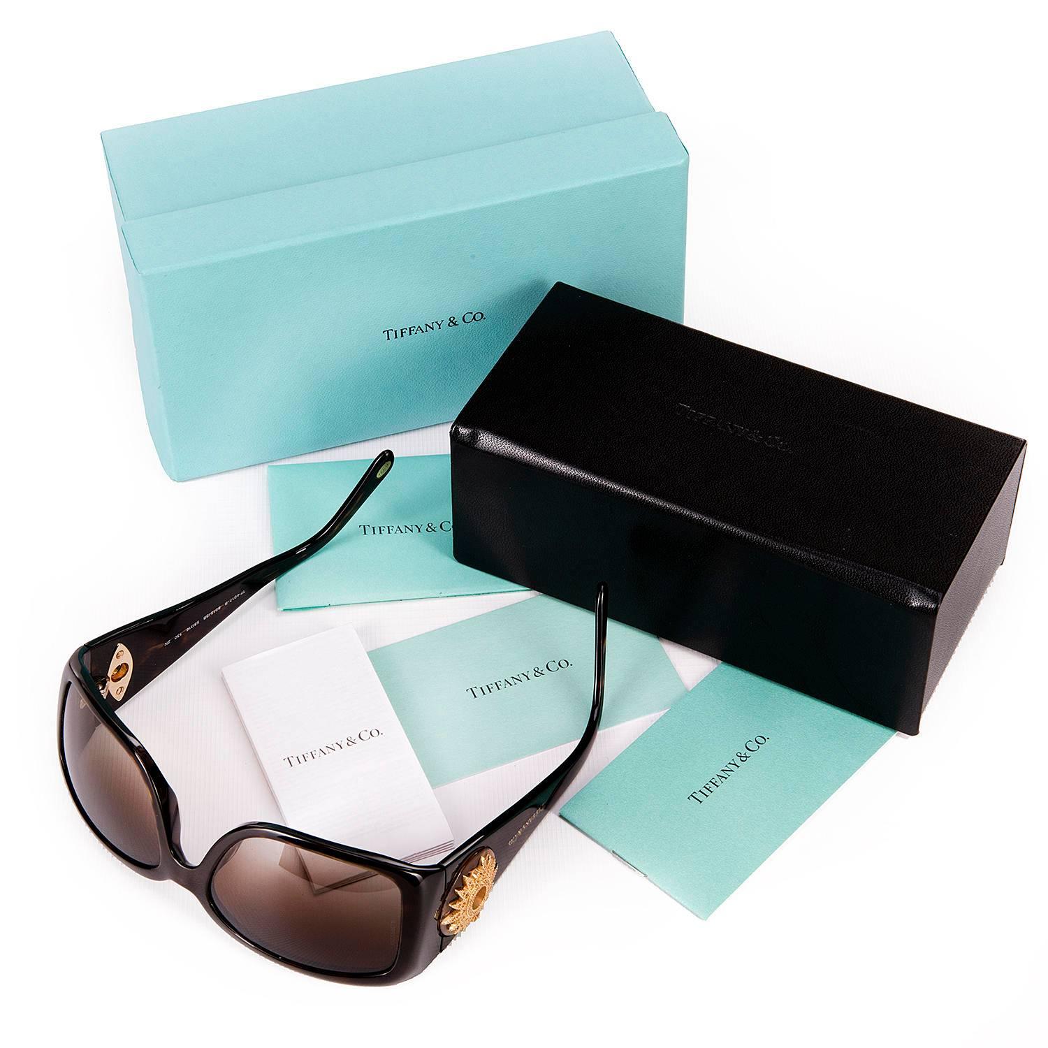 A Stunning Pair of Tiffany & Co. Sunglasses, the tortoiseshell frames decorated with Swarovski gilt-metal sunbursts, inset with amber cut-glass, 'grain' stones. In pristine, unworn, condition, the sunglasses are numbered TF 4017-B and come with the