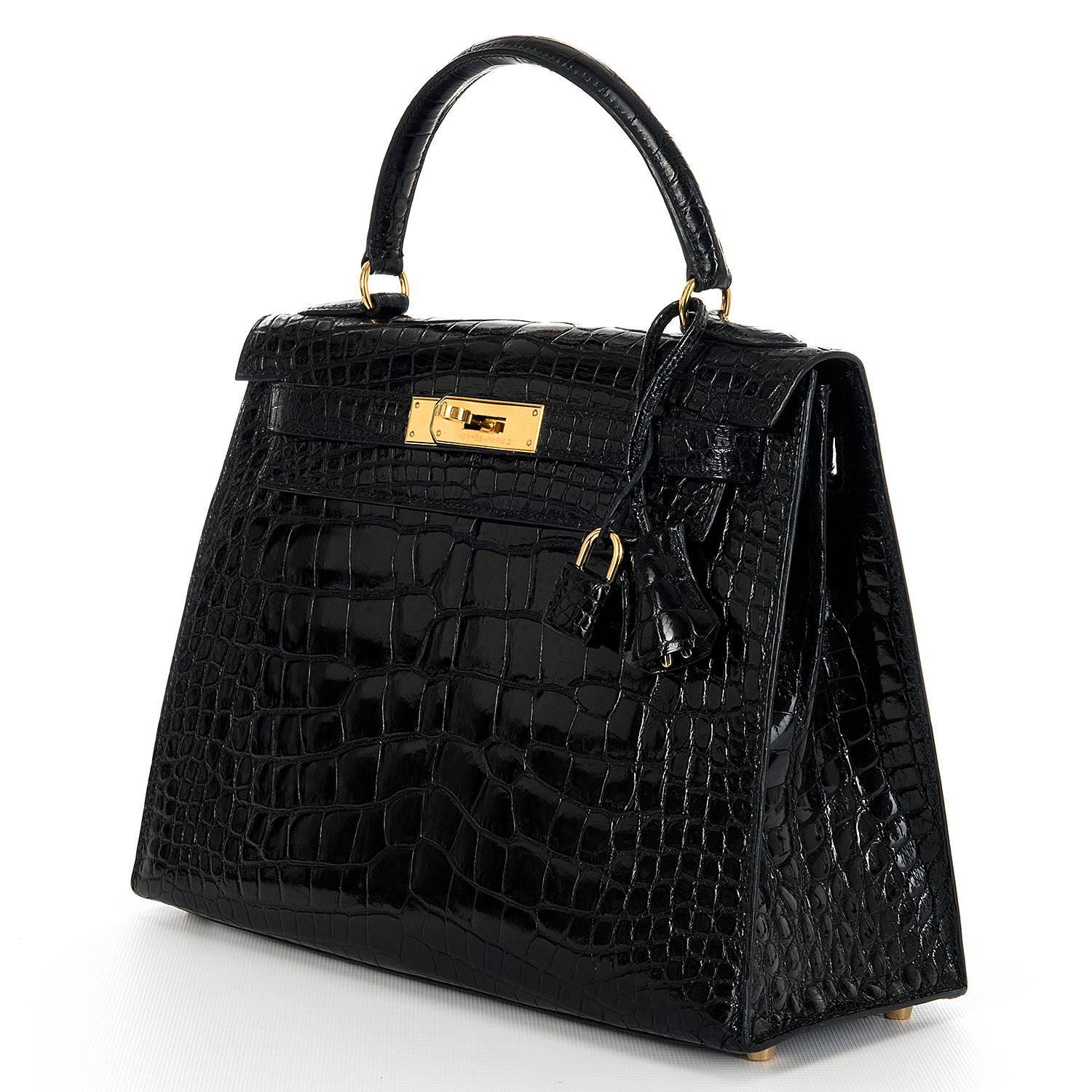 This Rare Hermes  28cm Shiny Black Crocodile Alligator Kelly Bag with Gold Hardware, is in pristine condition throughout. The interior is finish in Black Chèvre leather and has a full length zipped pocket, with an open pocket to the other side.