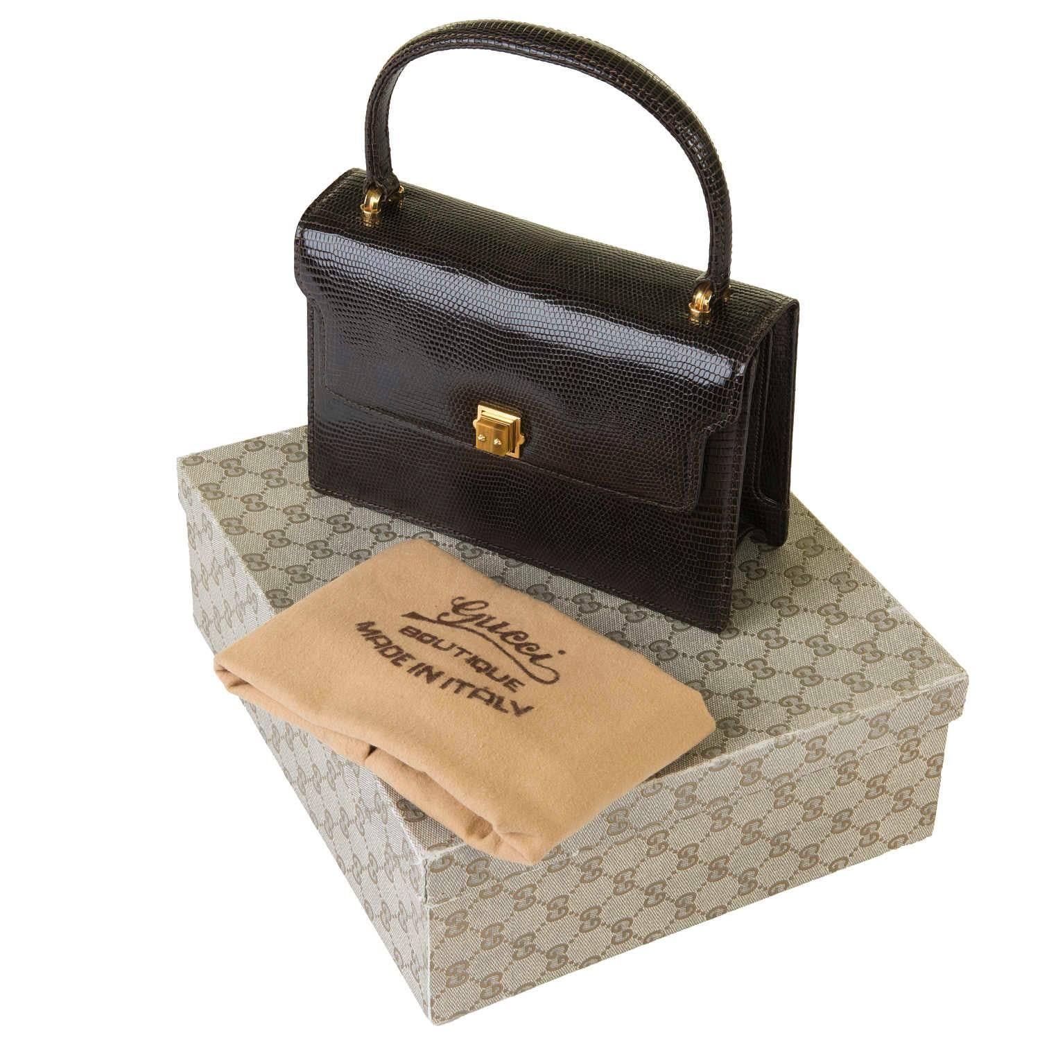 This Vintage, Special Order,  Gucci Chocolate Brown Lizard Handbag, made in circa 1970, is in pristine condition and remarkably comes with it's original dust sack and box. Certainly almost never used, the Lizard is complemented with gold tone
