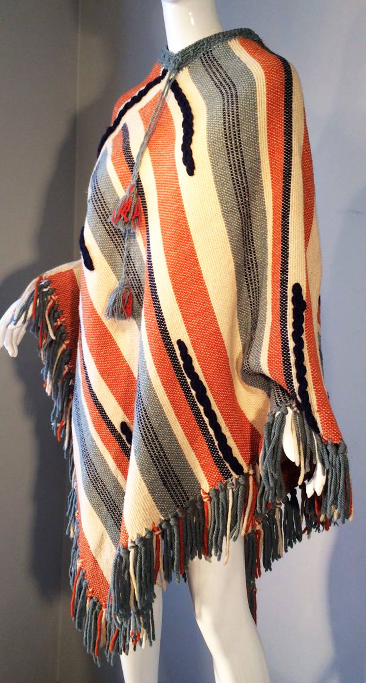 A fine and charming textile poncho ca.1960. Finely designed and woven wool fibers with hand constructed yarn trim and pulls. Rare item produced by Canadian textile designer, Monique Fortier.Excellent one size fits all item.