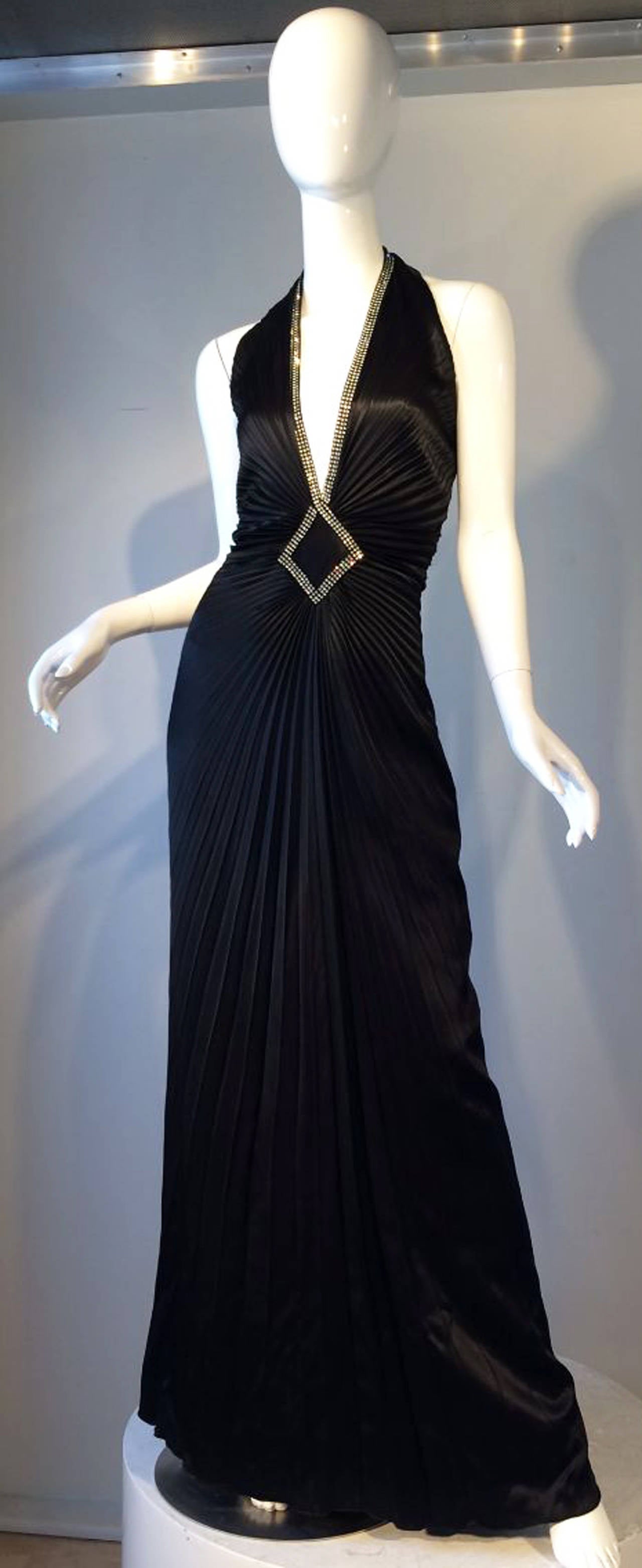 A fine and rare vintage Travilla 'jeweled' gown. Silky black starburst pleated fabric item with Swarovski crystal bodice trim. Item fully silk lined, zips up back. A iconic Hollywood starlet look from Travilla. Excellent.