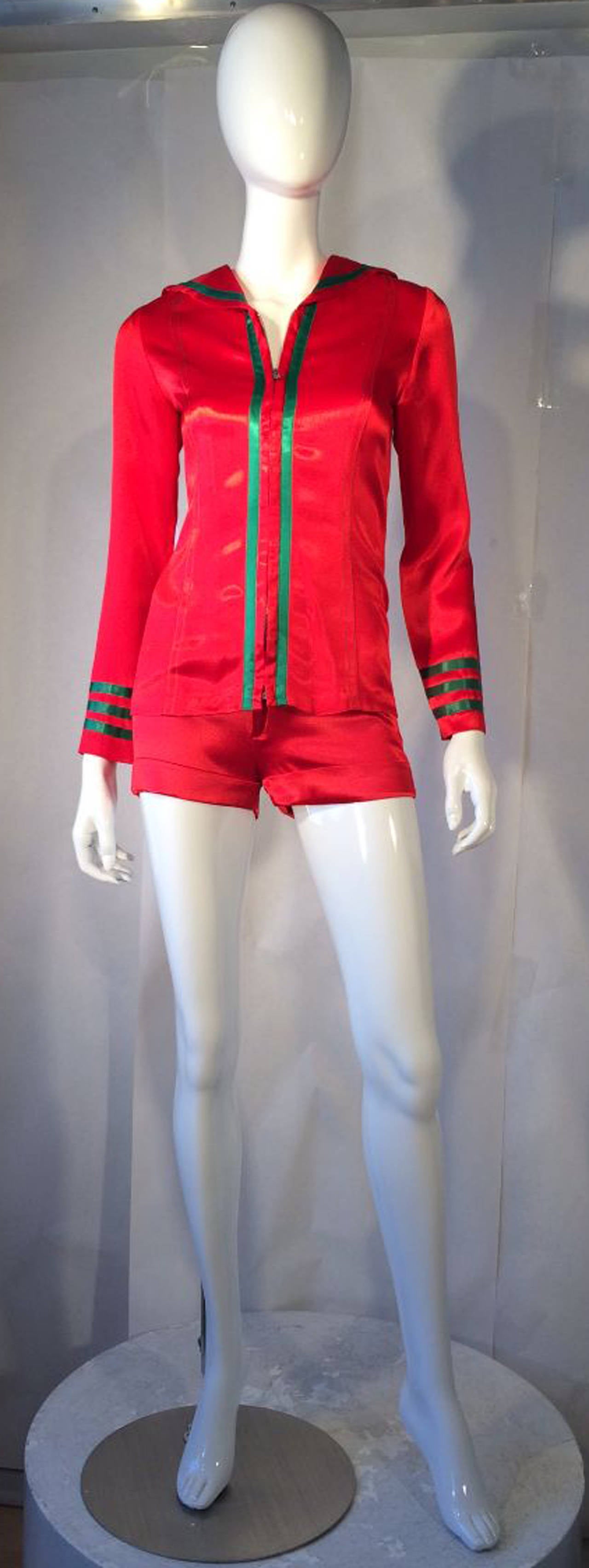 A fine and rare vintage Mr. Freedom 2pc. satin sailor suit. Iconic Pop Art item previously owned and worn by Astrid Wyman, 1969. Shiny and vibrant red silk satin items feature contrasting green satin trim and applique yolk details. Both top and hot