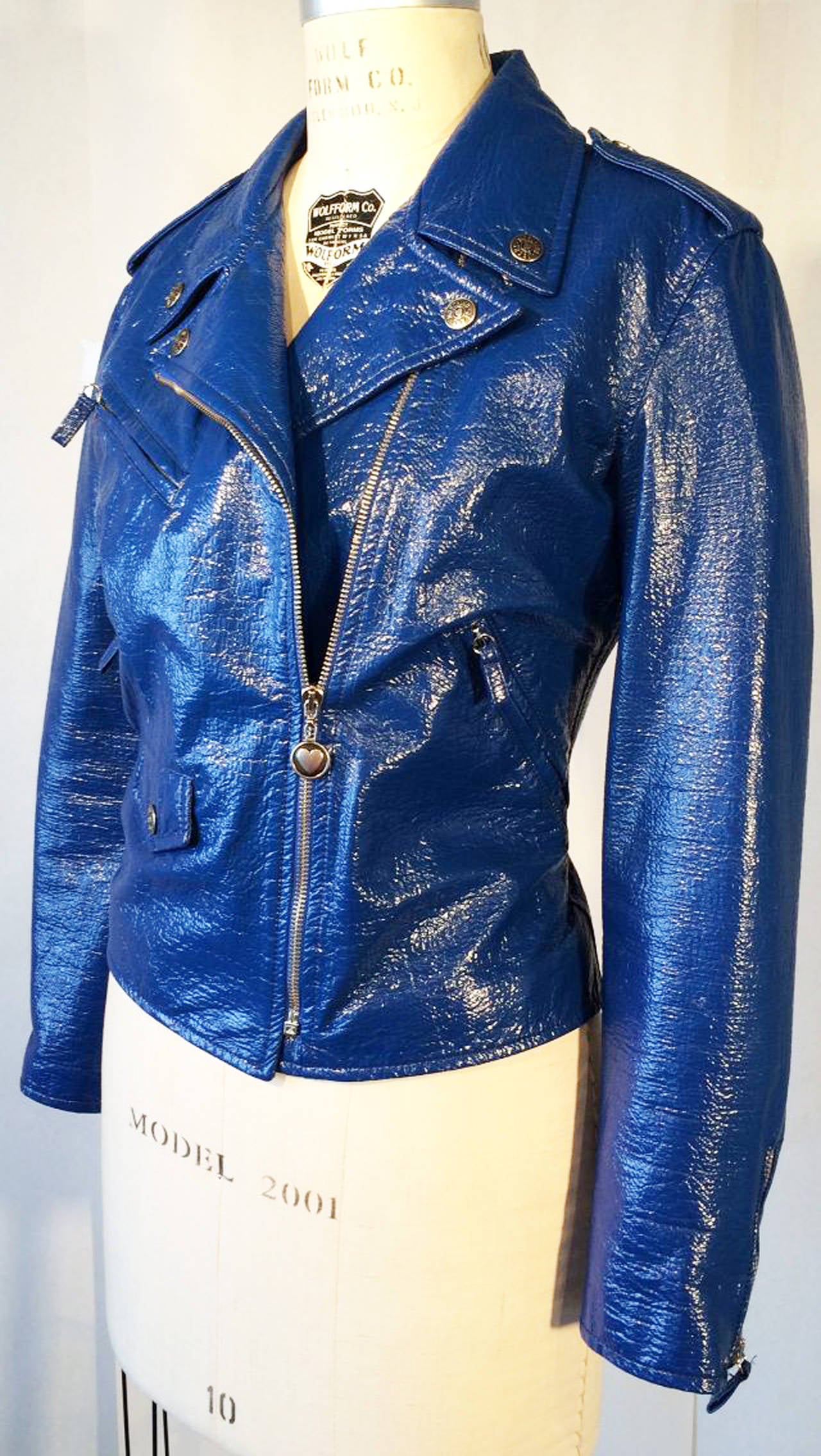 A fine and rare vintage Moschino vinyl motorcycle/biker jacket. Vibrant blue crinkle patent vinyl item fully silky lined with zipper and snap closures. Pristine appears unworn.