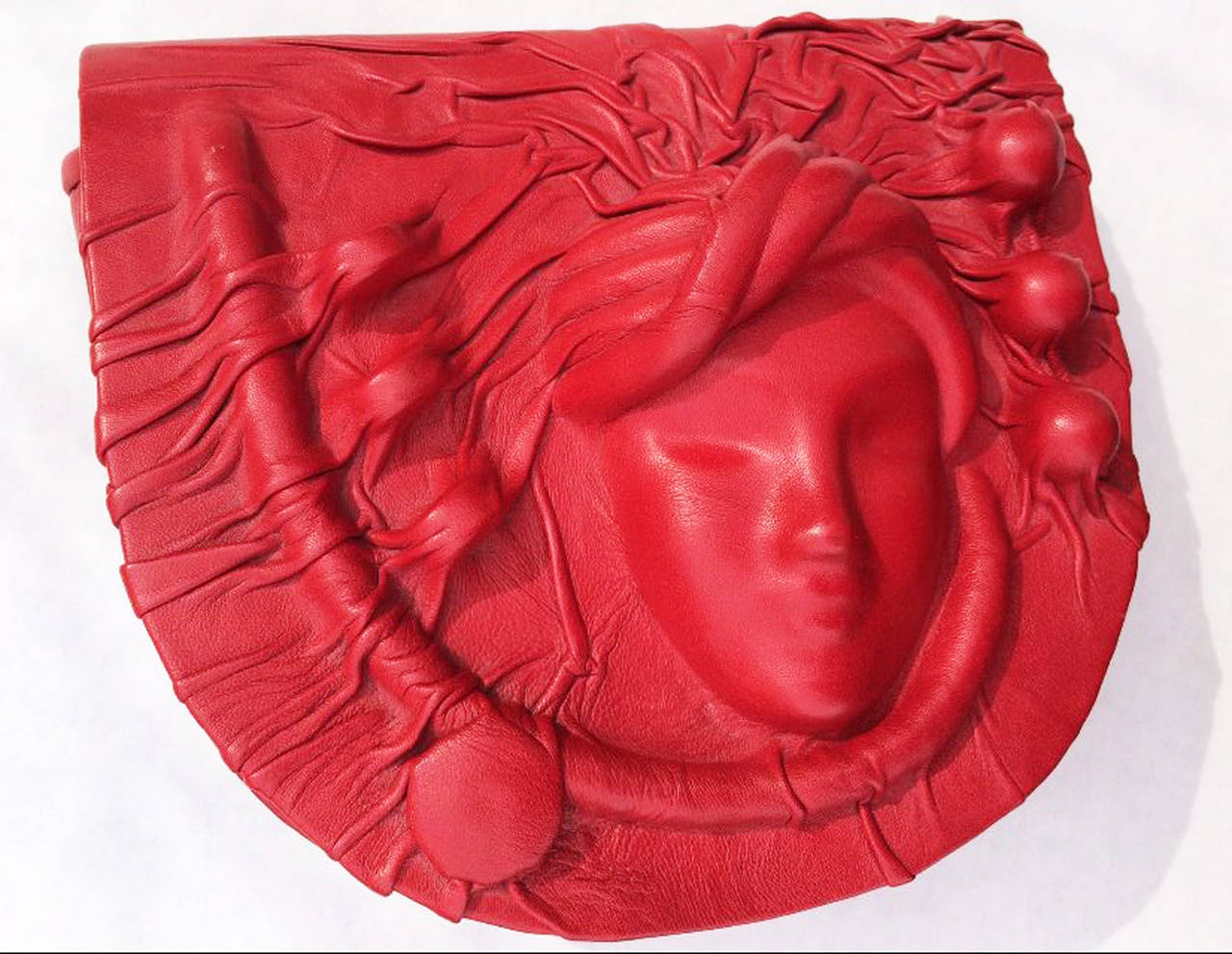 A fine vintage sculpted leather clutch handbag. Molded and sculpted vibrant red leather item features a fold-over magnetic flap closure and drop matching 37