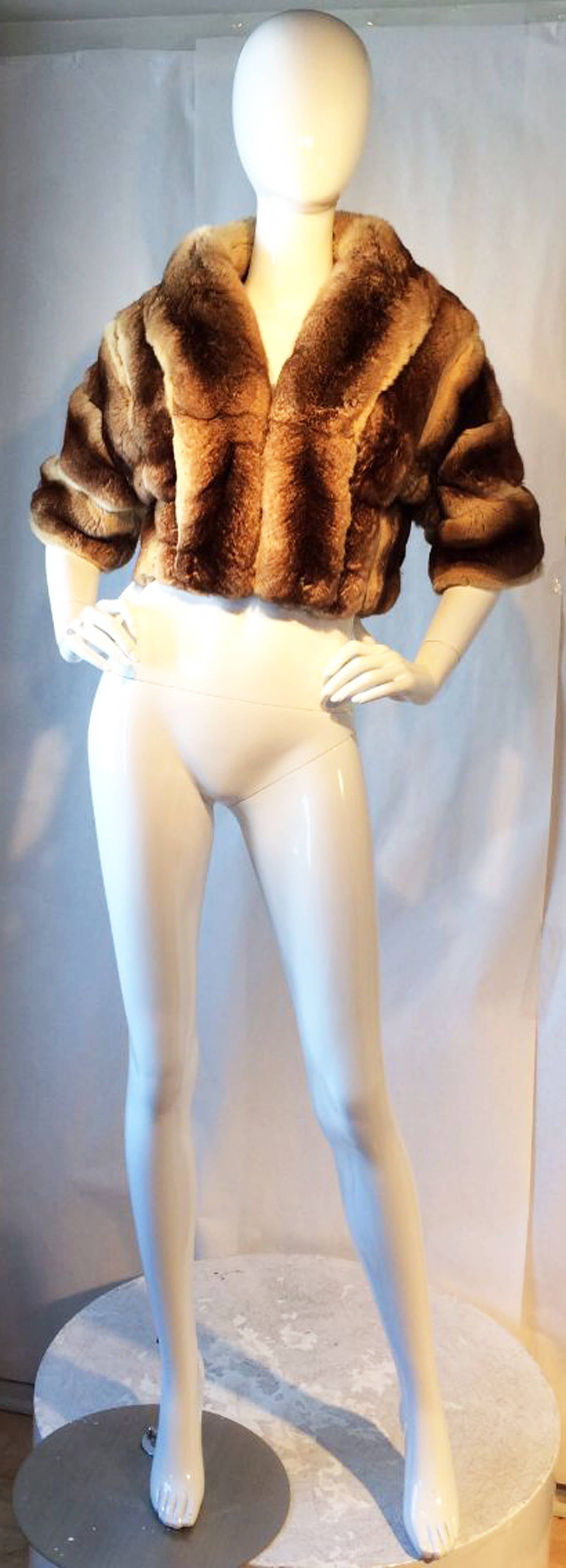 A fine and rare Michael Kors couture chinchilla shrug jacket. Authentic custom order item in a rare mocha dyed chinchilla fur. Item features matching fur attached collar and cuffs, fully silk lined with hidden hook closures. Pristine appears unworn.