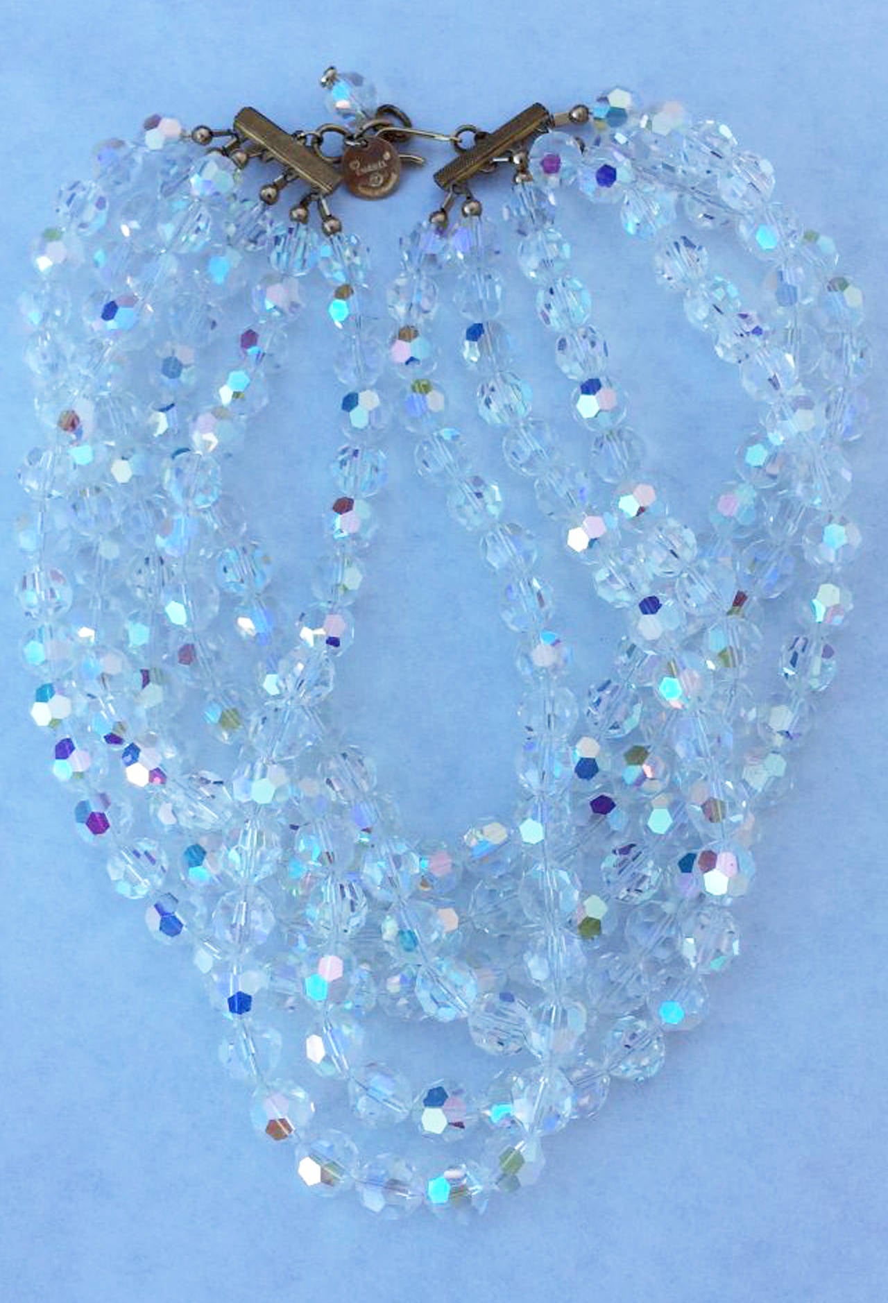 A fine and rare vintage Chanel crystal torsade necklace. Signed six-strand faceted crystal beads item feature a aurora borealis finish and original gilt metal chain and hook closure. Pristine with original signature box intact.