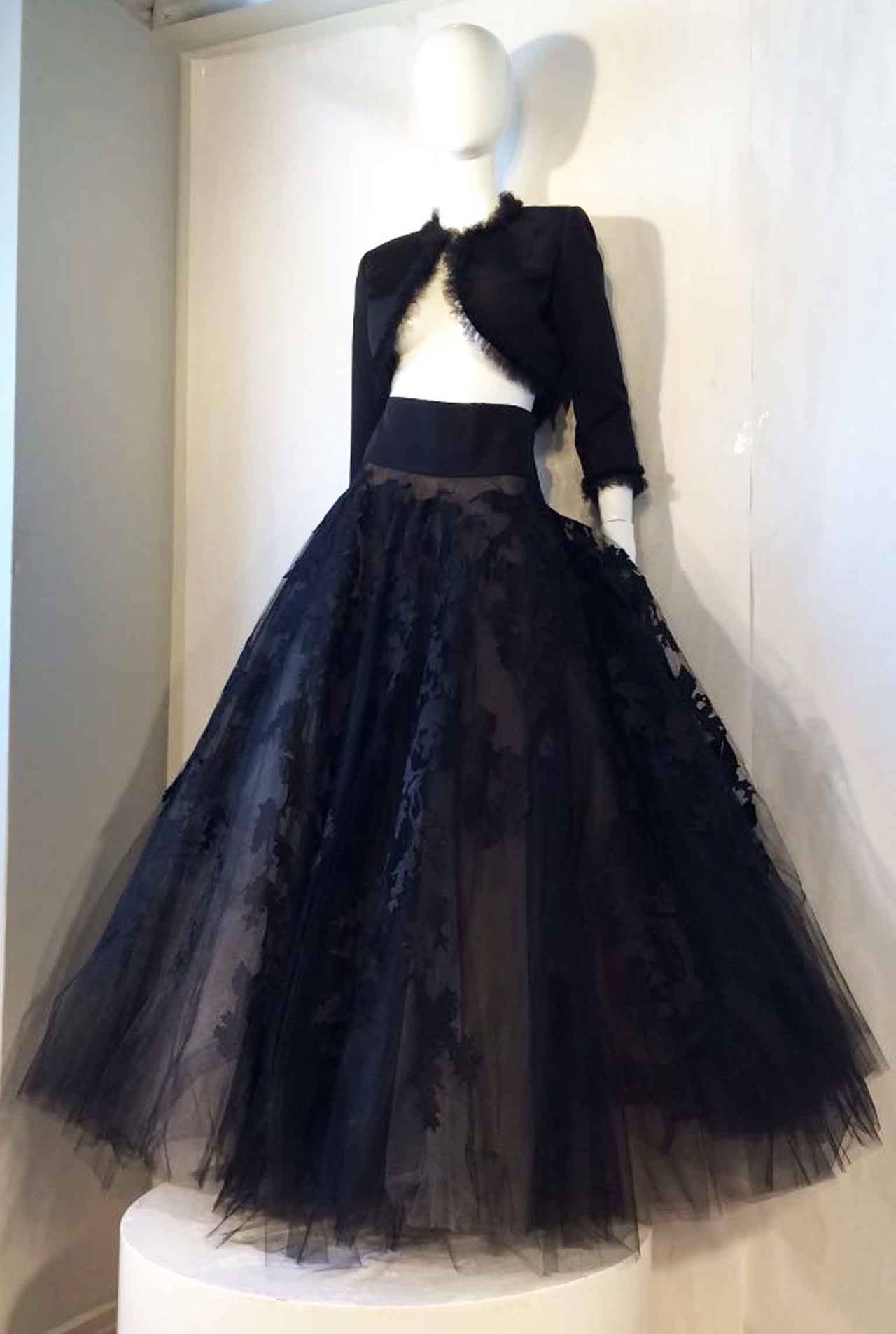 A exquisite and rare vintage Oscar de La Renta ball gown ensemble. Super fine black silk faille fabric cropped jacket trimmed with ruffle tulle and no front closures. Matching skirt features a matching fabric waistband, massive multiple layer tulle