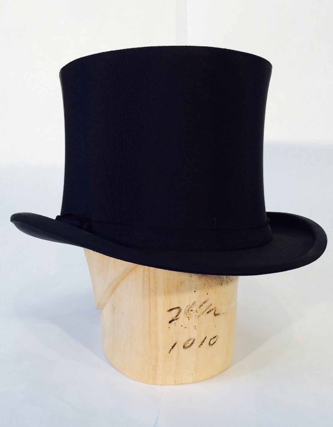 A fine vintage gents silk top hat. Authentic black collaspible item fully silk lined with a matching period hat box. Hat measures 6