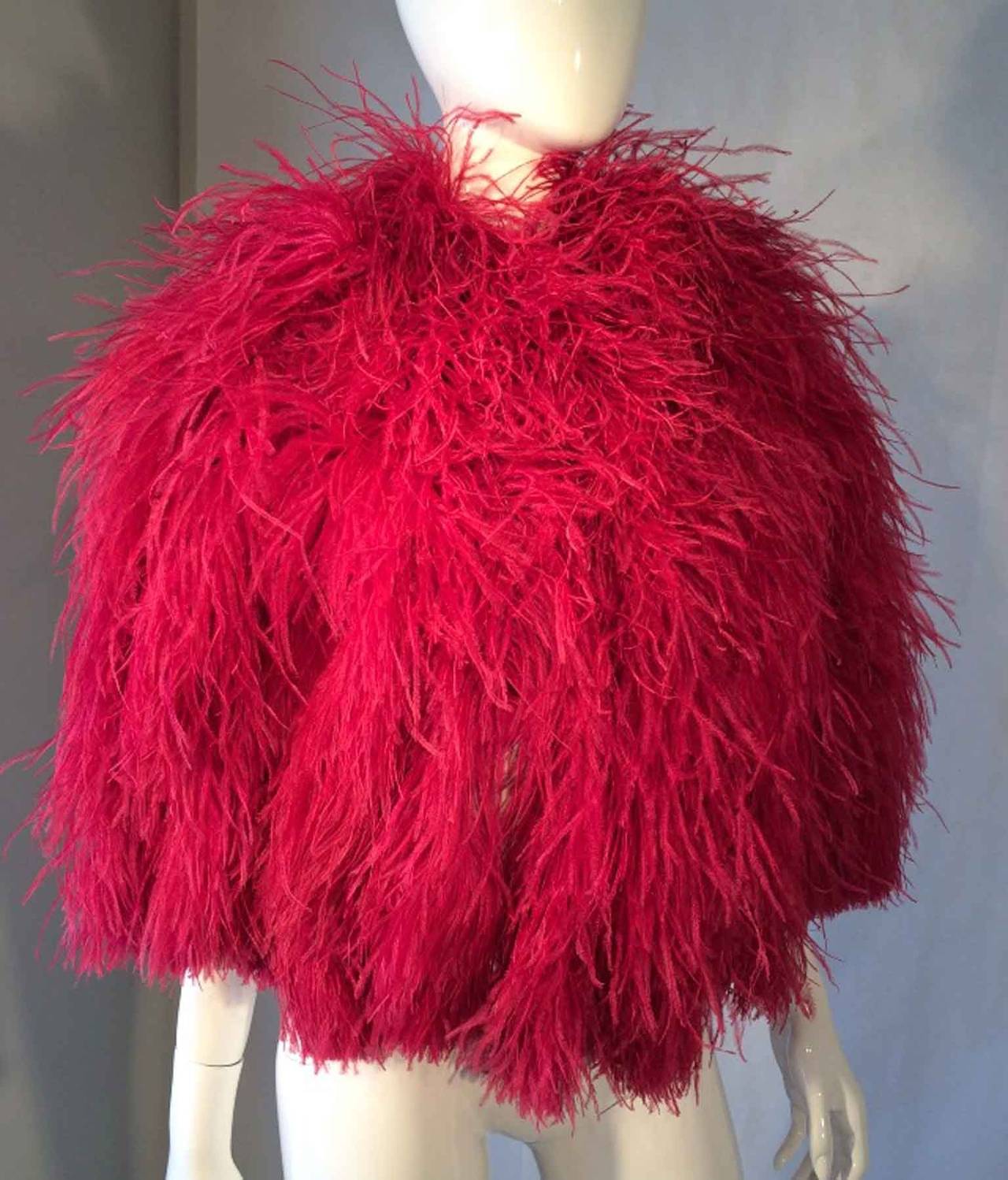 A fine vintage ostrich feather cape. Vivid raspberry dyed feather item fully silk crepe lined with single hook closure at neck. Authentic item for Saks Fifth Avenue. Excellent with no issues.