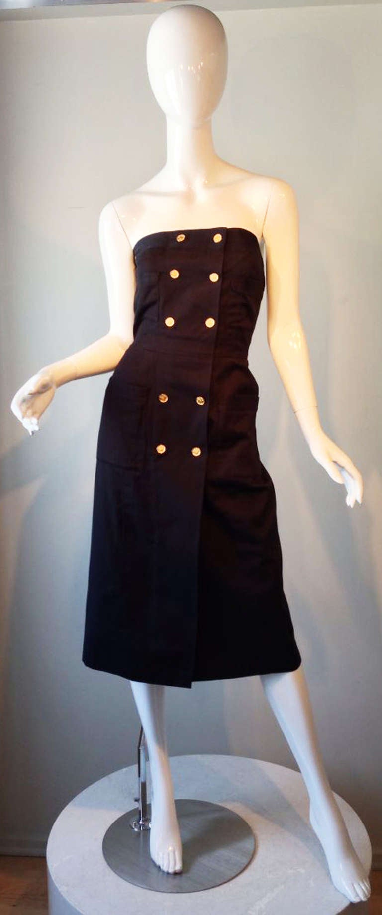 A fine vintage Chanel Summer cocktail dress. Fine black cotton pique fabric items features a faux wrap front and gilt metal 