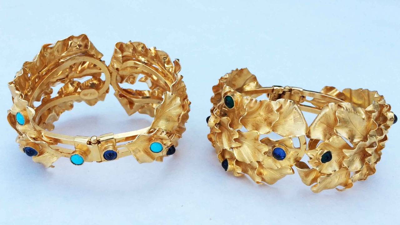 A fine and rare pair vintage William de Lillo cuff bracelets. Signed sculpted gilt metal wreaths feature art glass cabochon 