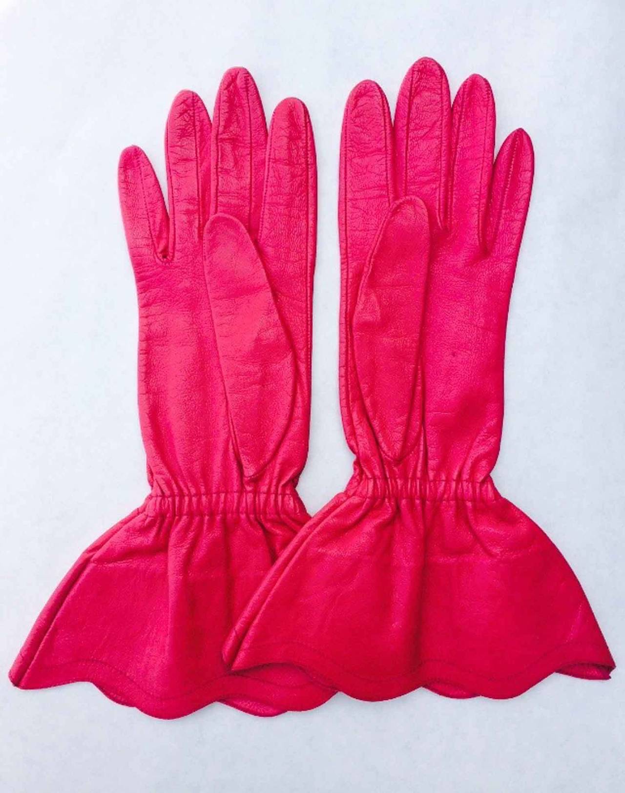 A fine and rare pair Yves Saint Laurent Gloves. Vivid and supple pink leather items fully lined and appear unworn. Size 7.