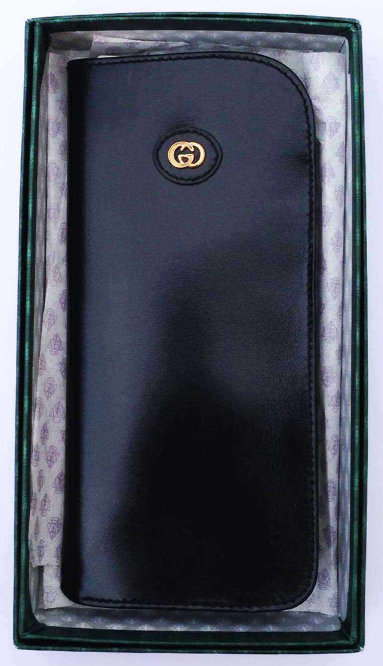 A fine vintage Gucci eyewear case. Unused signed polished black leather item features a gilt logo detail. Pocket form (no closures) item retains original signature box.