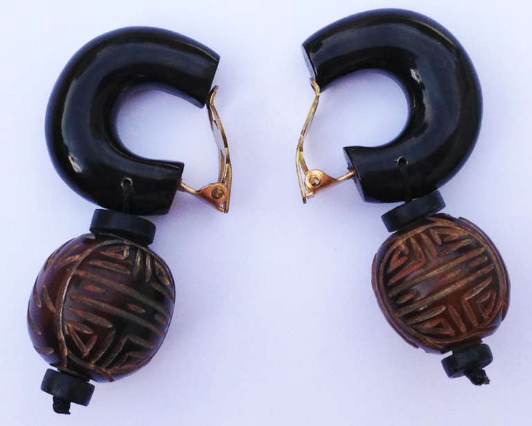A fine and rare pair vintage Yves Saint Laurent ear clips. Polished wood demi-hoop suspends a carved bead drop. Original gilt metal ear clips intact. Unsigned.