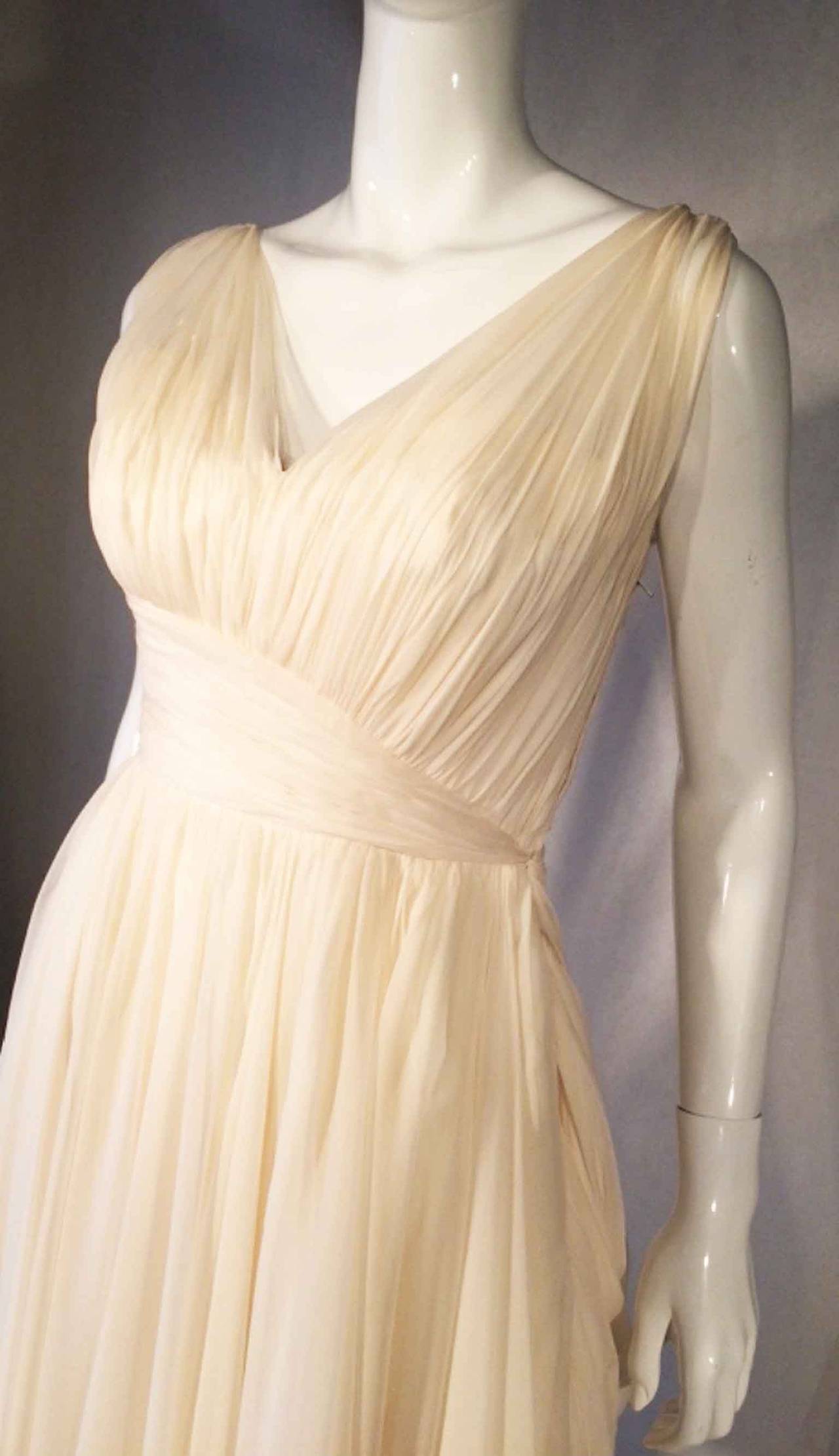 A fine and rare vintage Jean Desses haute couture cocktail dress. Hand constructed multi-layered ivory white silk chiffon item features a sculpted boned bodice, shoulder straps and draped skirt panels. Item fully lined with metal zipper up side.
