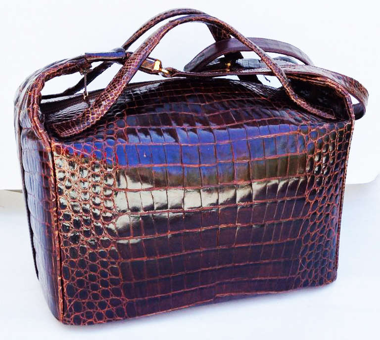 A fine and rare vintage Lancel porosus crocodile travel bag. Item custom ordered and constructed, 1974. Rich dark brown polished skins item features a welted construction, attached matching handles and shoulder strap (16